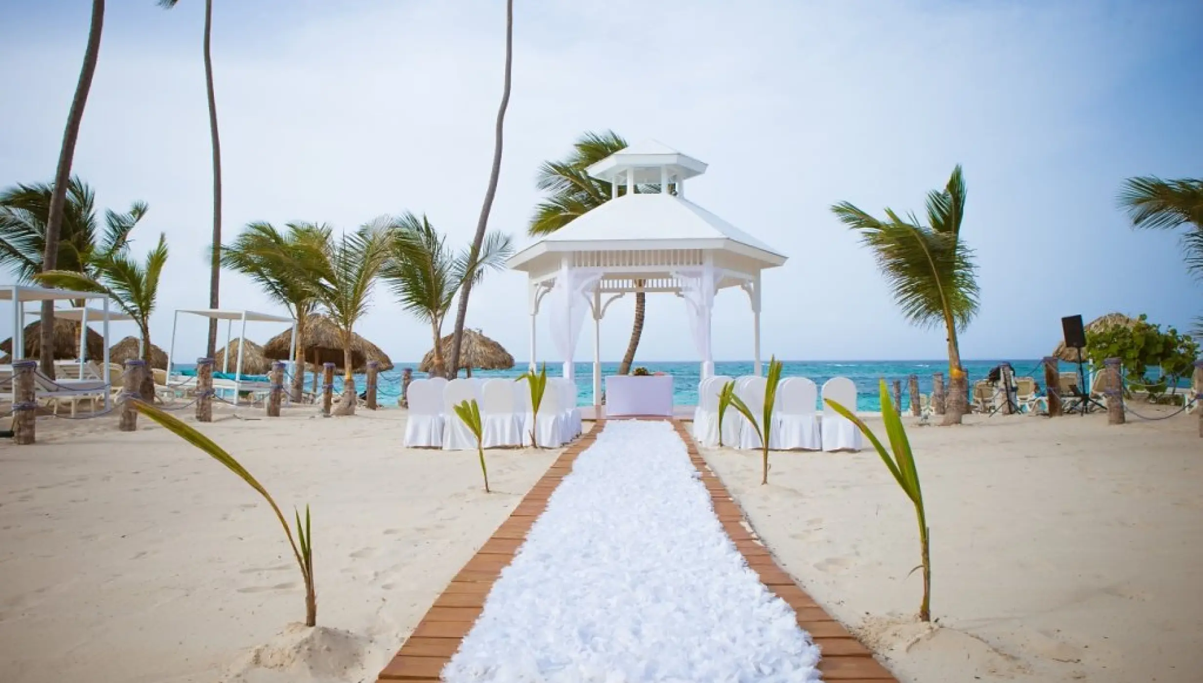 White beach ceremony gazebo with a floral runner at Majestic Mirage, Punta Cana