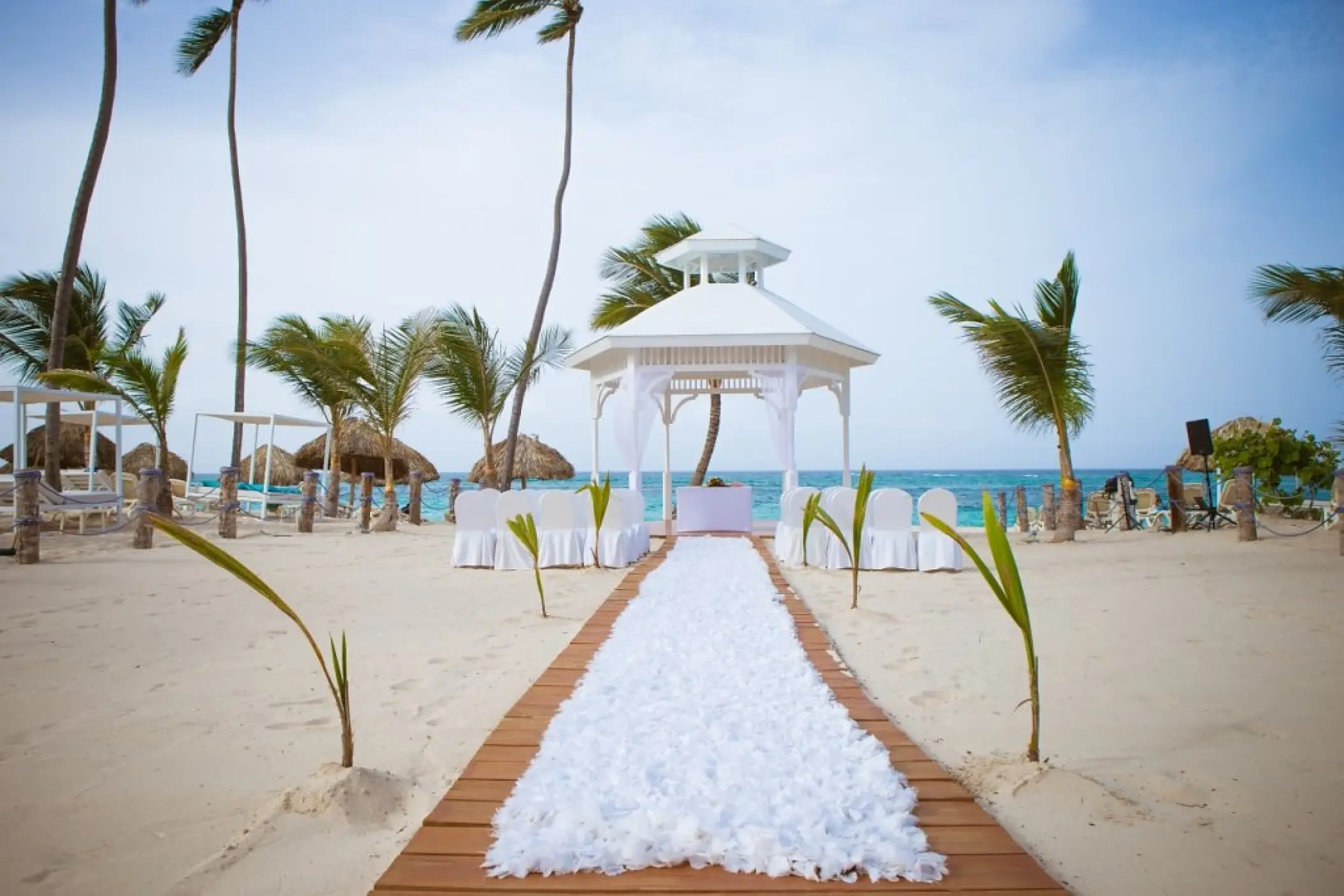 White beach ceremony gazebo with a floral runner at Majestic Mirage, Punta Cana