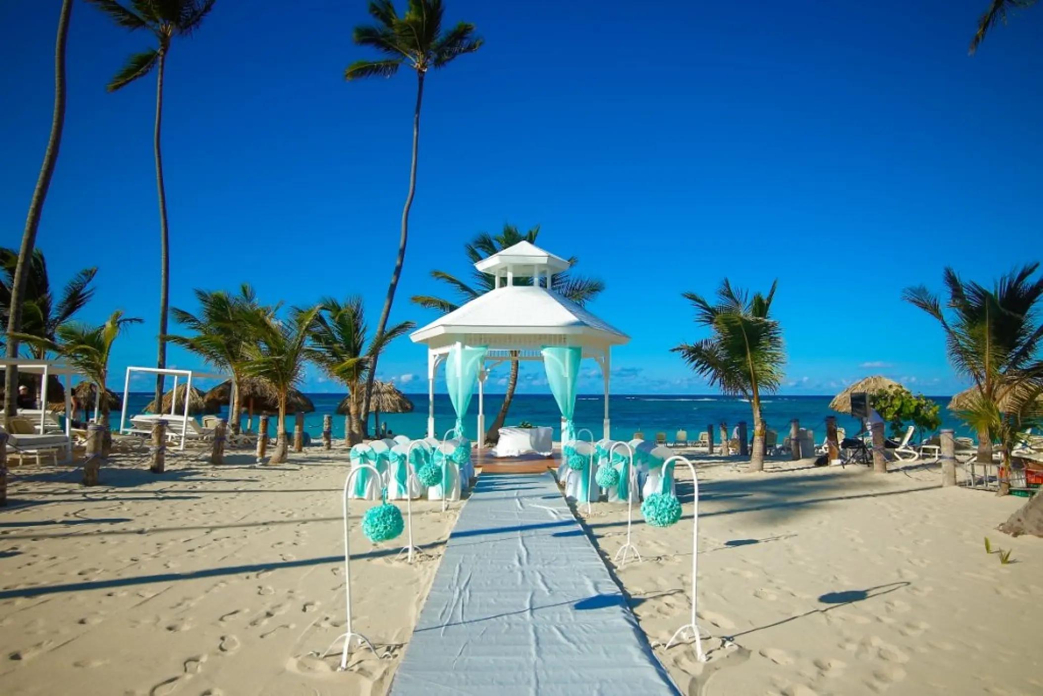 Beachfront wedding ceremony gazebo with teal decor at Majestic Mirage, Punta Cana