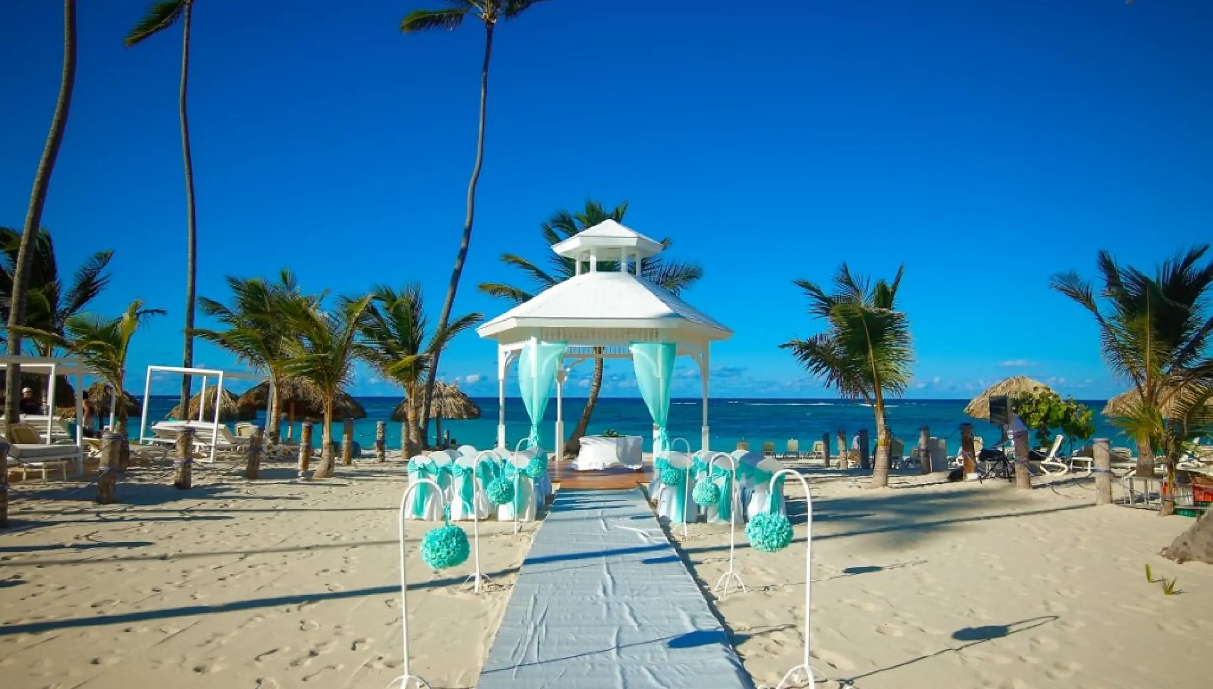 Beachfront wedding ceremony gazebo with teal decor at Majestic Mirage, Punta Cana