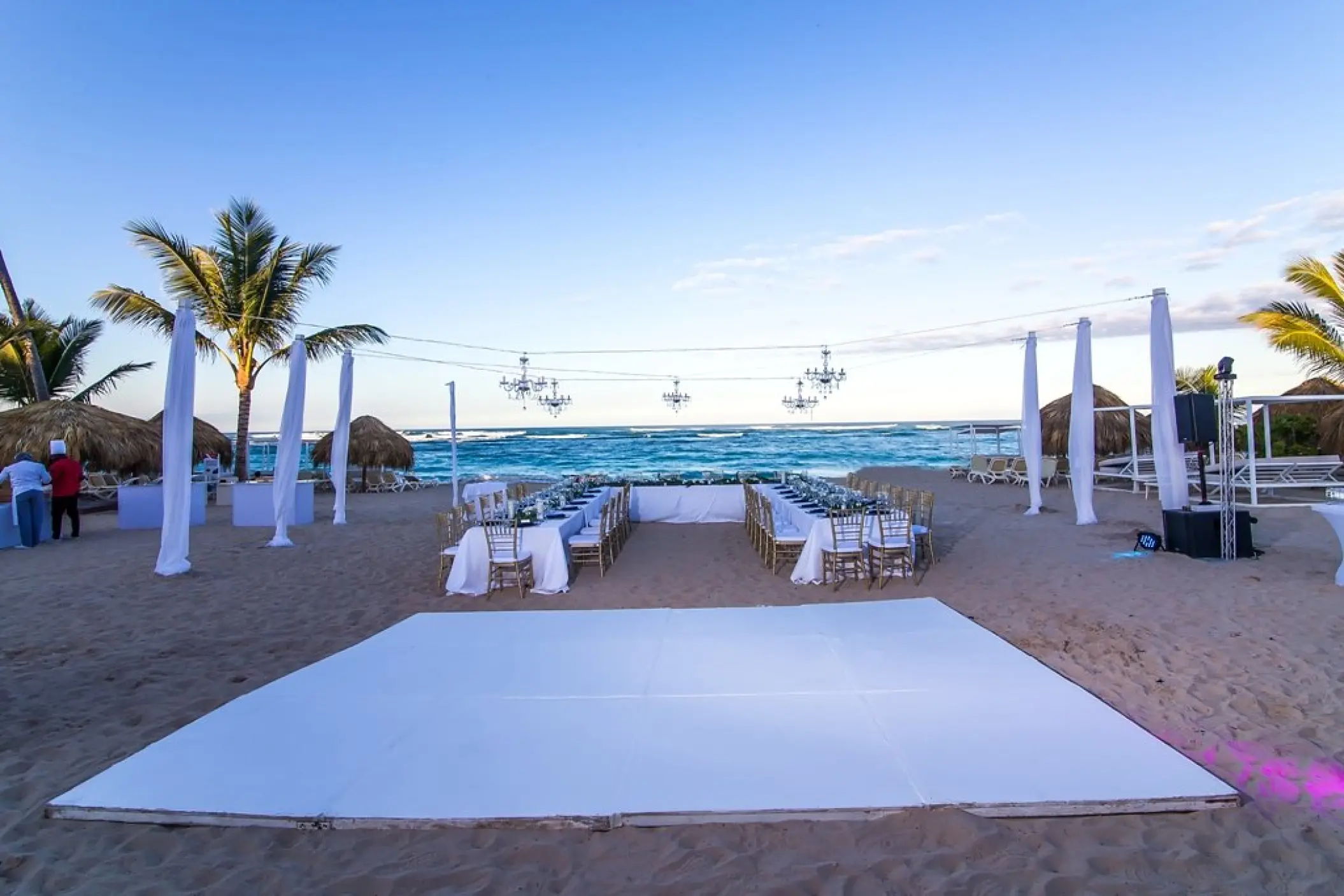 Beachfront wedding reception setup with white dance floor and chandeliers at Majestic Mirage, Punta Cana