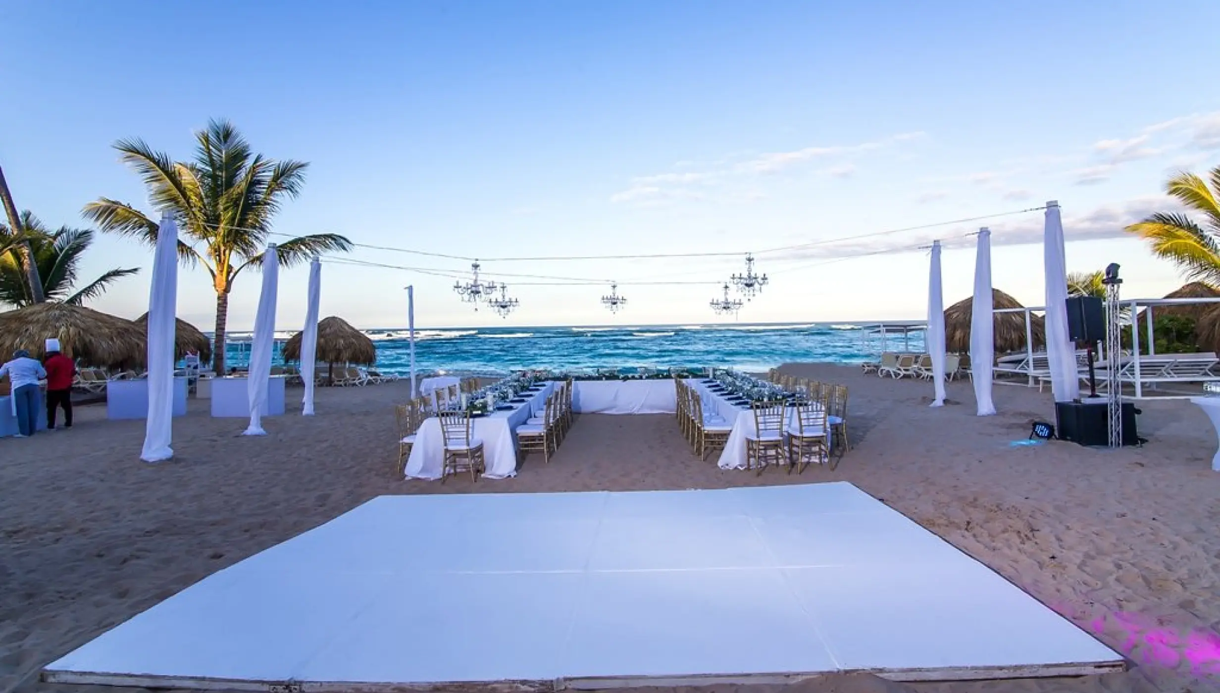 Beachfront wedding reception setup with white dance floor and chandeliers at Majestic Mirage, Punta Cana