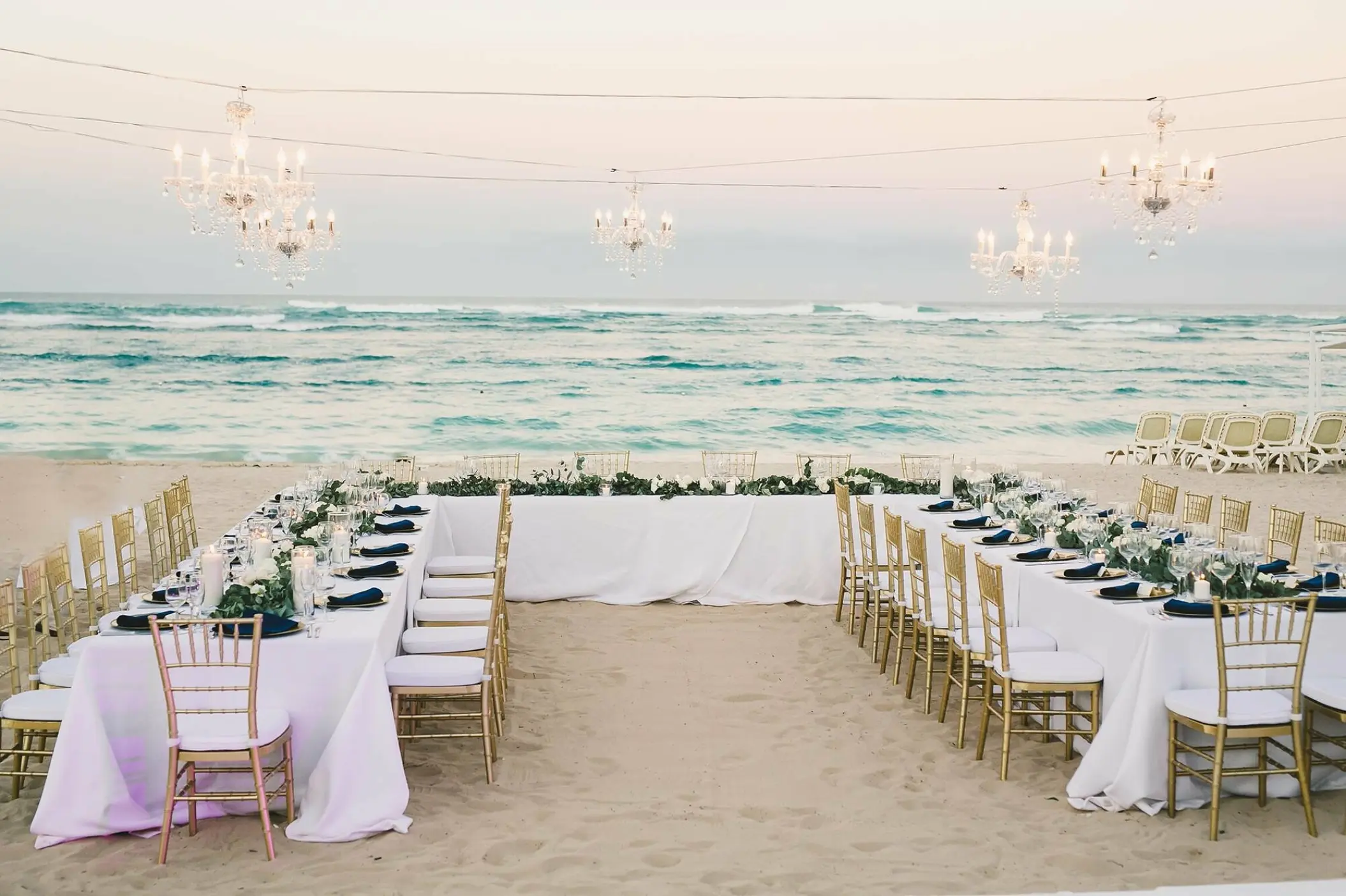 Beachfront wedding reception with chandeliers and gold chairs at Majestic Mirage, Punta Cana