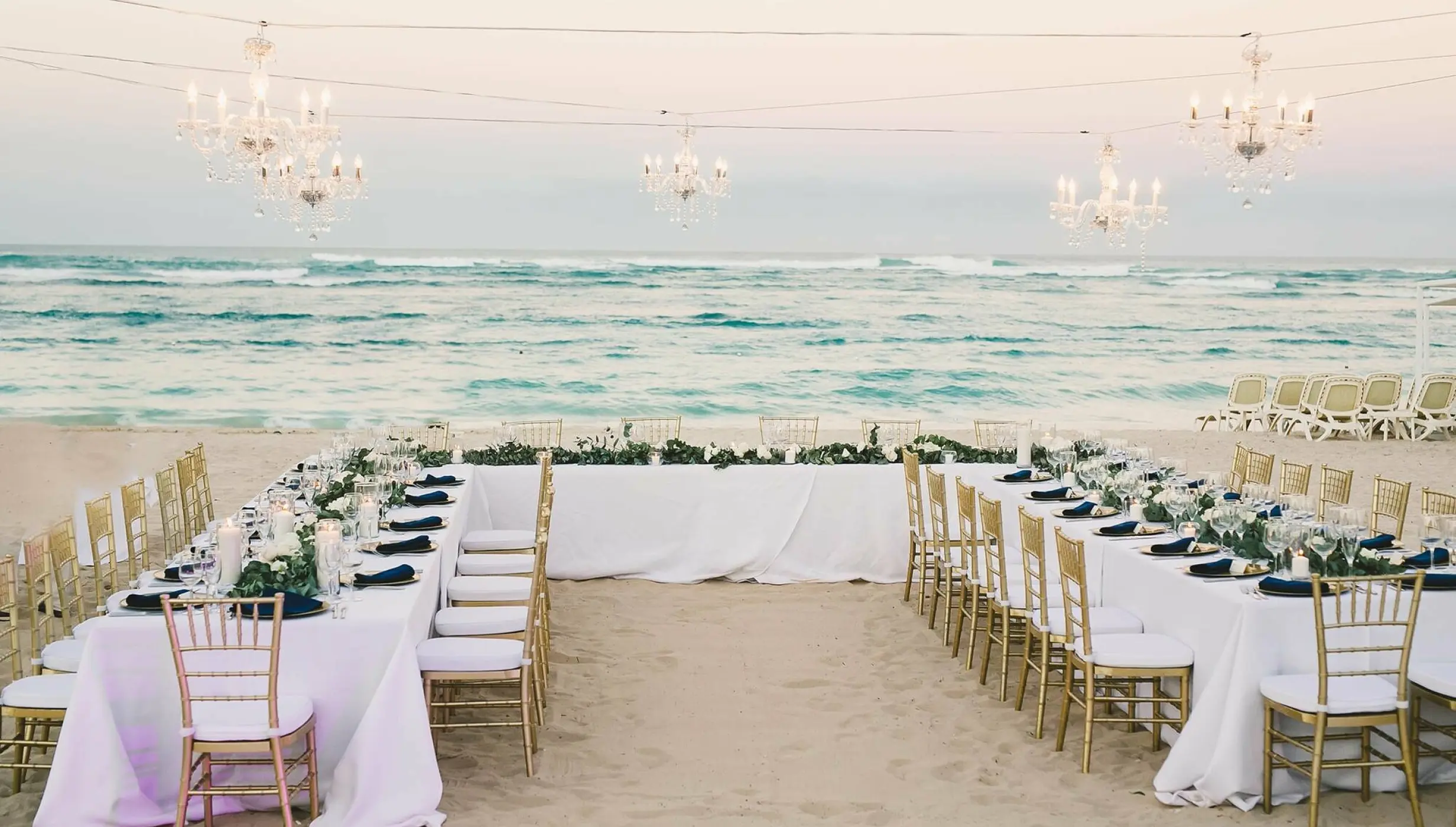 Beachfront wedding reception with chandeliers and gold chairs at Majestic Mirage, Punta Cana
