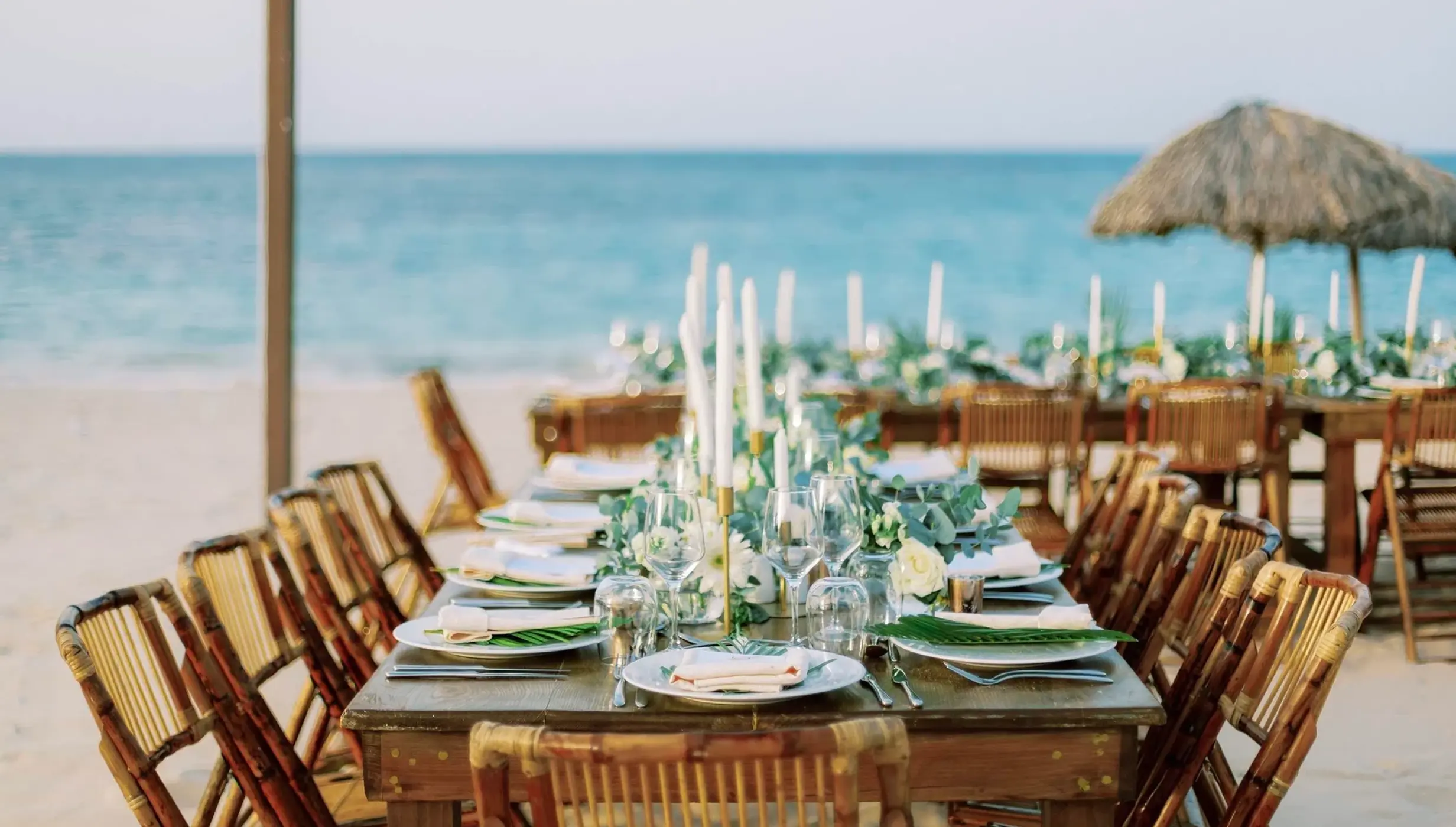 Beachfront wedding reception setup with wooden tables and bamboo chairs at Majestic Mirage, Punta Cana
