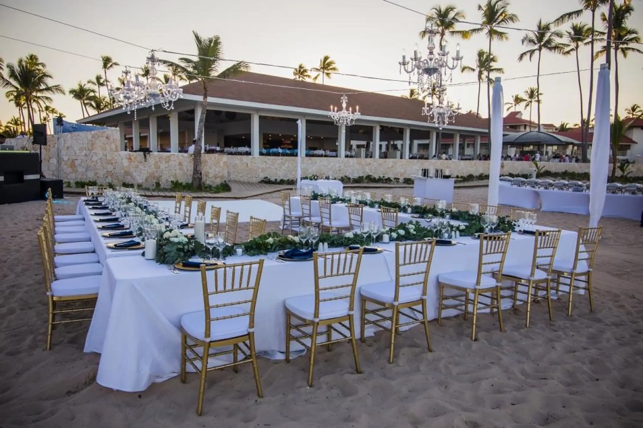 Beach wedding reception with gold chairs and crystal chandeliers at Majestic Mirage, Punta Cana