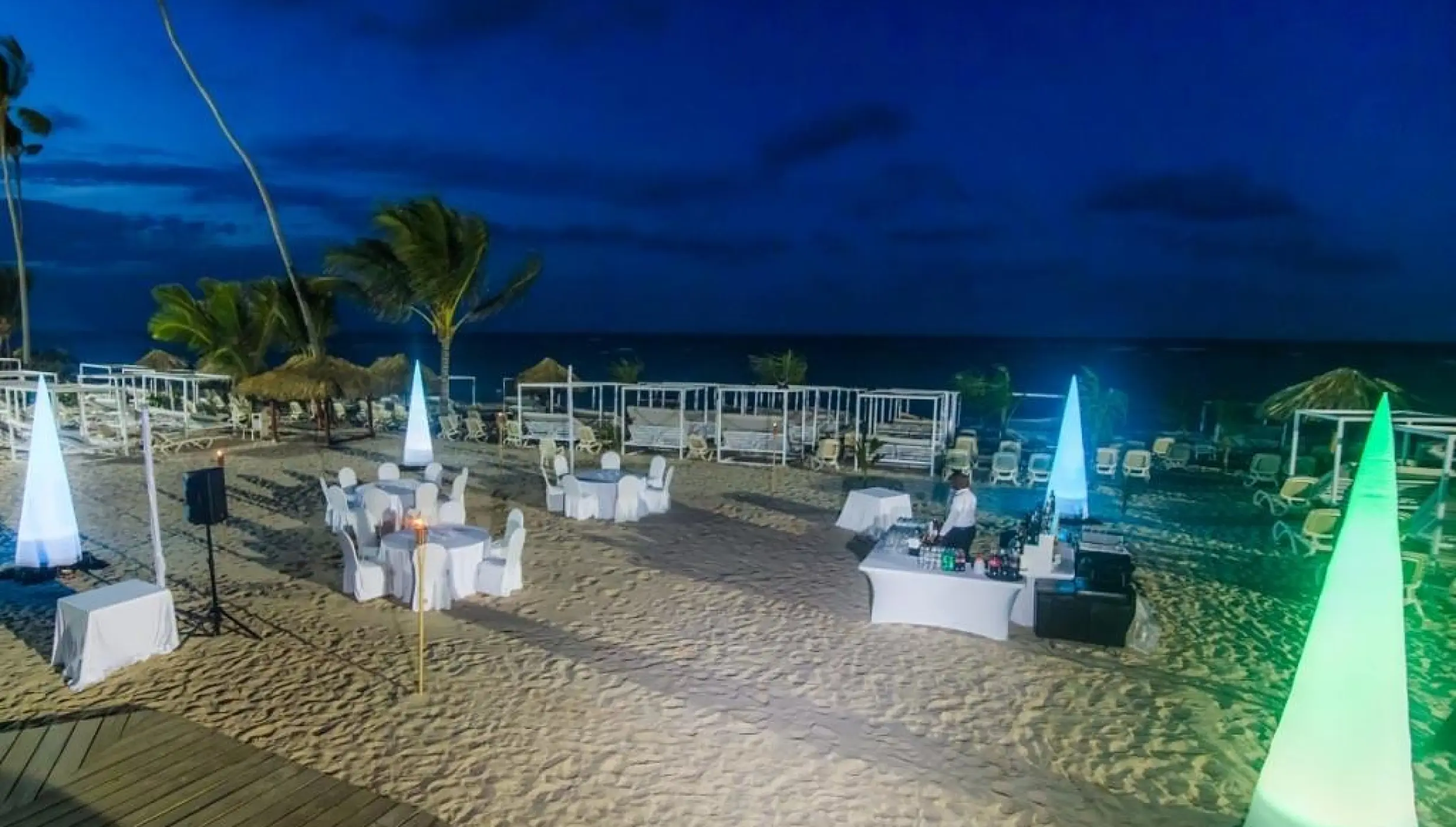 Evening beach wedding reception with illuminated cone décor at Majestic Mirage, Punta Cana