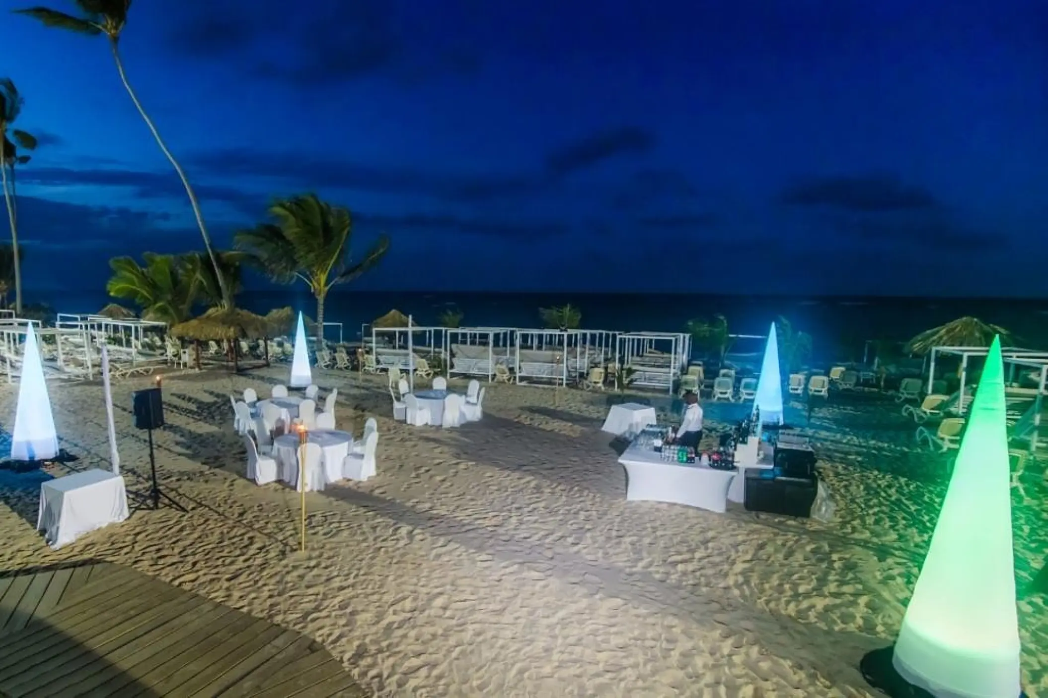 Evening beach wedding reception with illuminated cone décor at Majestic Mirage, Punta Cana