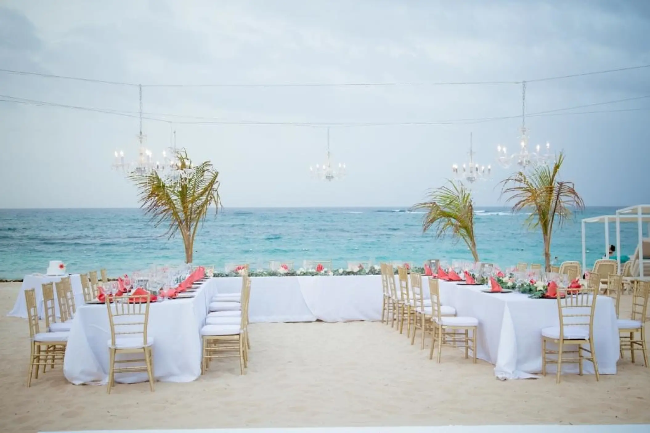 Beachfront wedding reception with chandeliers and gold chairs at Majestic Mirage, Punta Cana