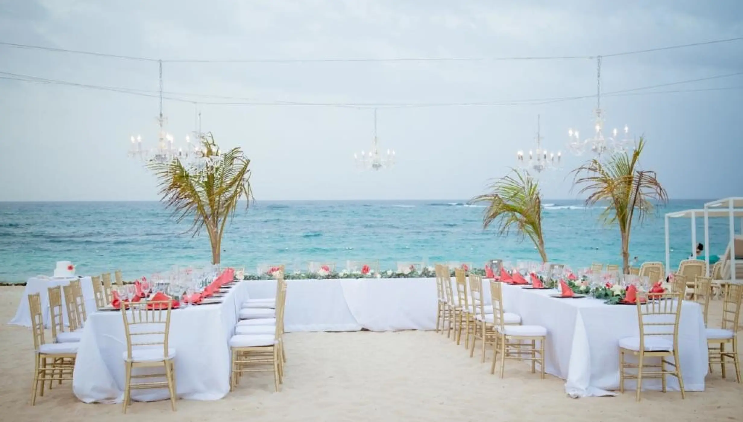 Beachfront wedding reception with chandeliers and gold chairs at Majestic Mirage, Punta Cana