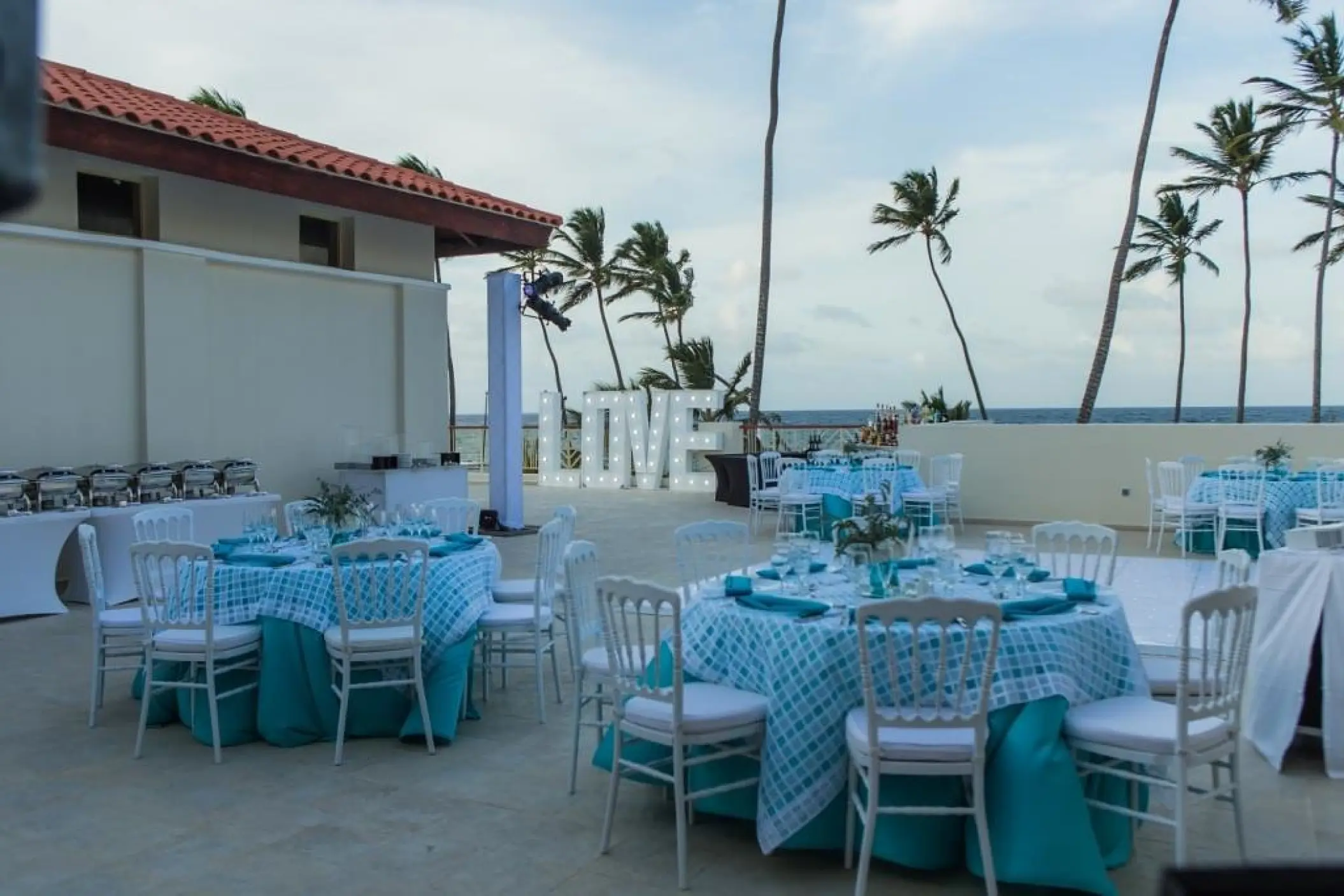 Private terrace wedding reception with teal décor and marquee LOVE sign at Majestic Mirage, Punta Cana