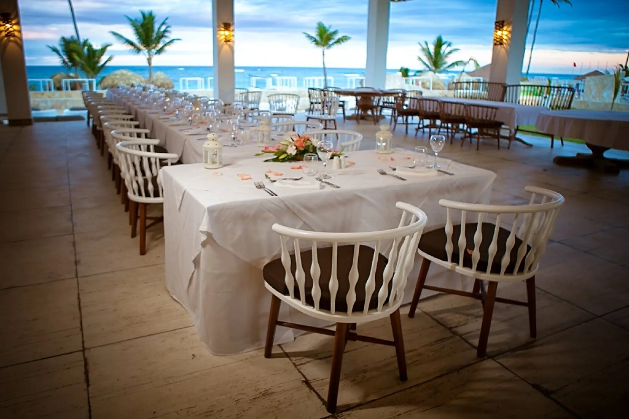 Covered seaside wedding reception venue with white tables and chairs at Majestic Mirage, Punta Cana