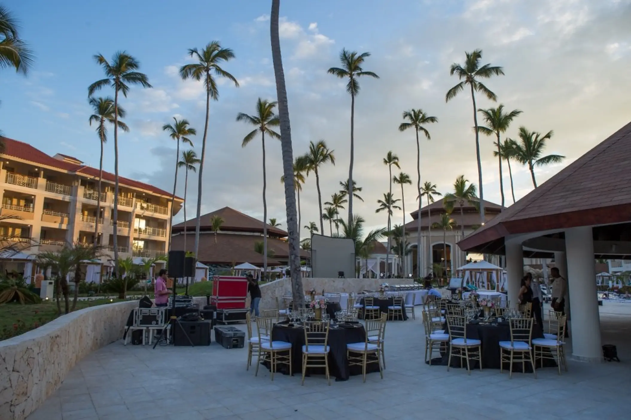 Outdoor wedding reception setup with round tables and tall palm trees at Majestic Mirage, Punta Cana