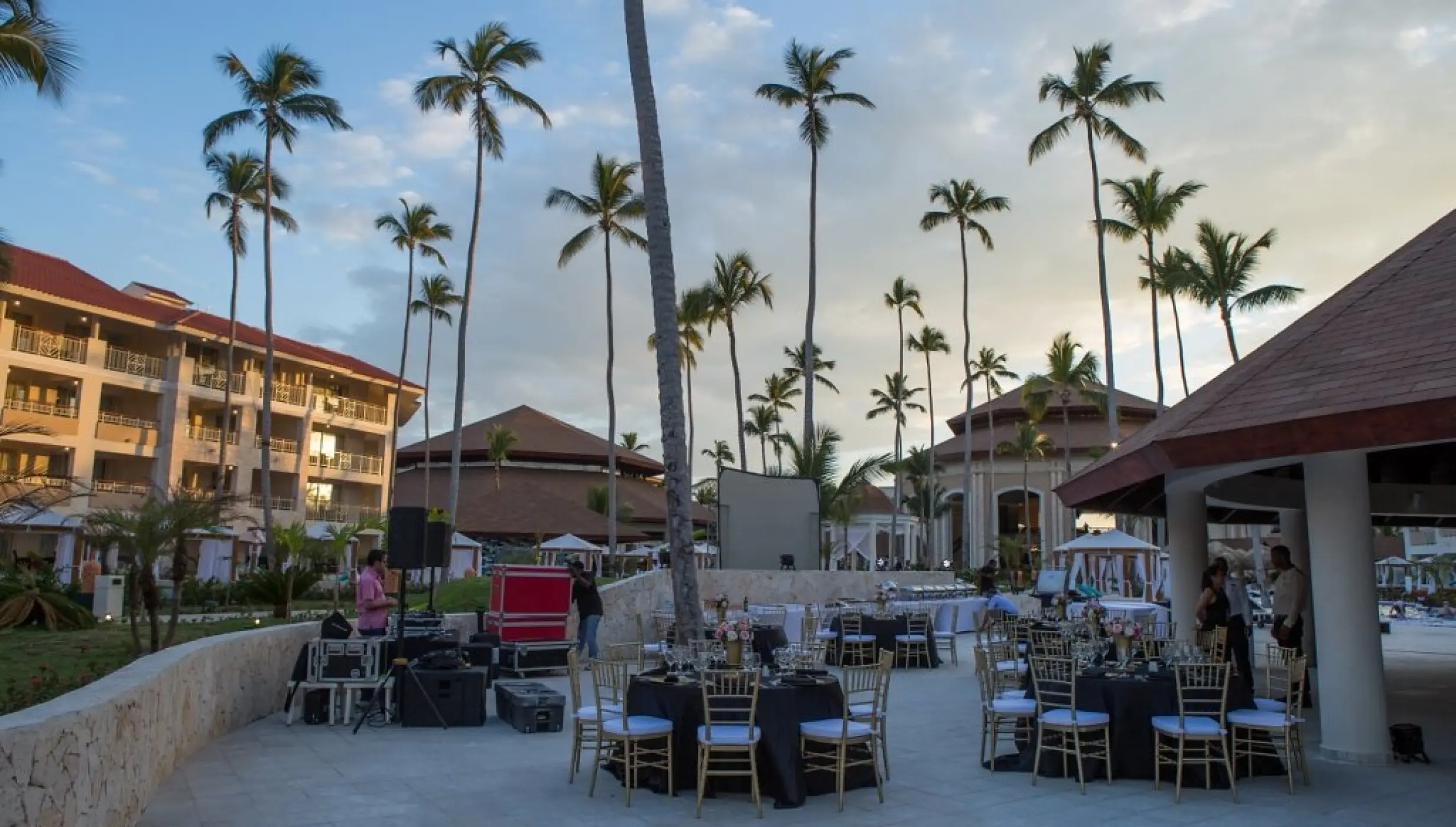 Outdoor wedding reception setup with round tables and tall palm trees at Majestic Mirage, Punta Cana
