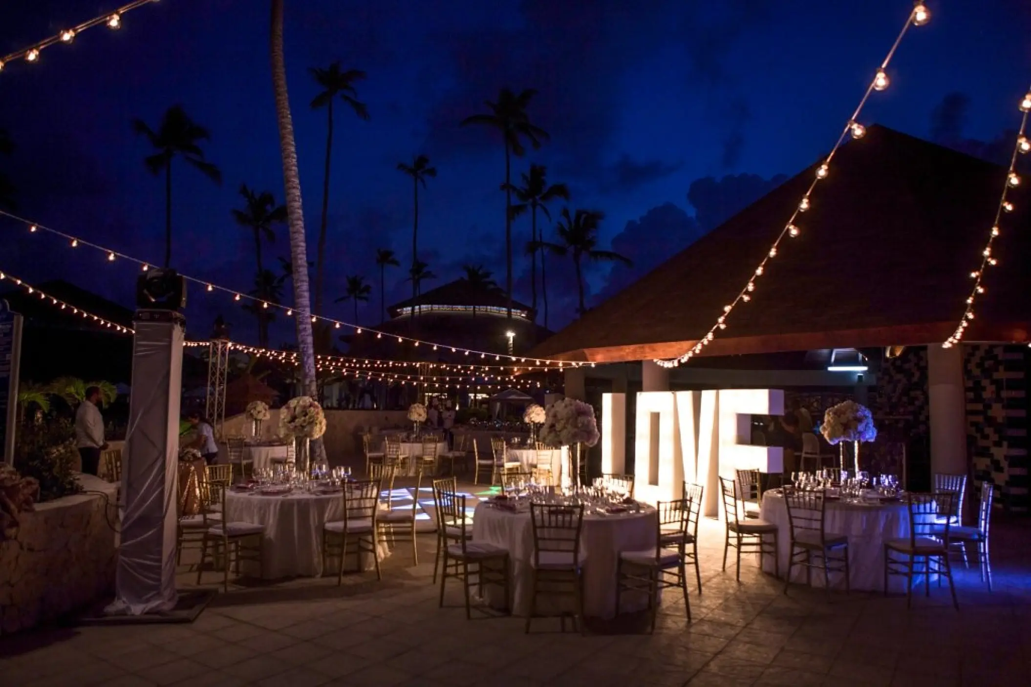 Outdoor wedding reception with string lights and illuminated LOVE sign at Majestic Mirage, Punta Cana