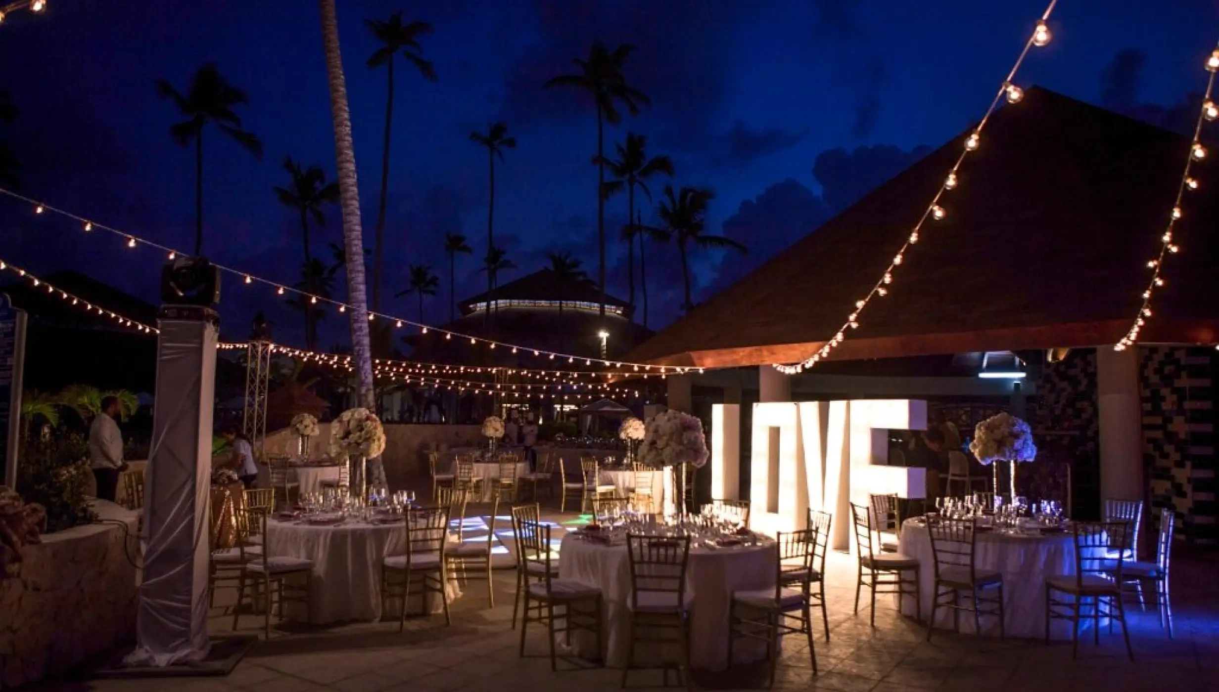 Outdoor wedding reception with string lights and illuminated LOVE sign at Majestic Mirage, Punta Cana