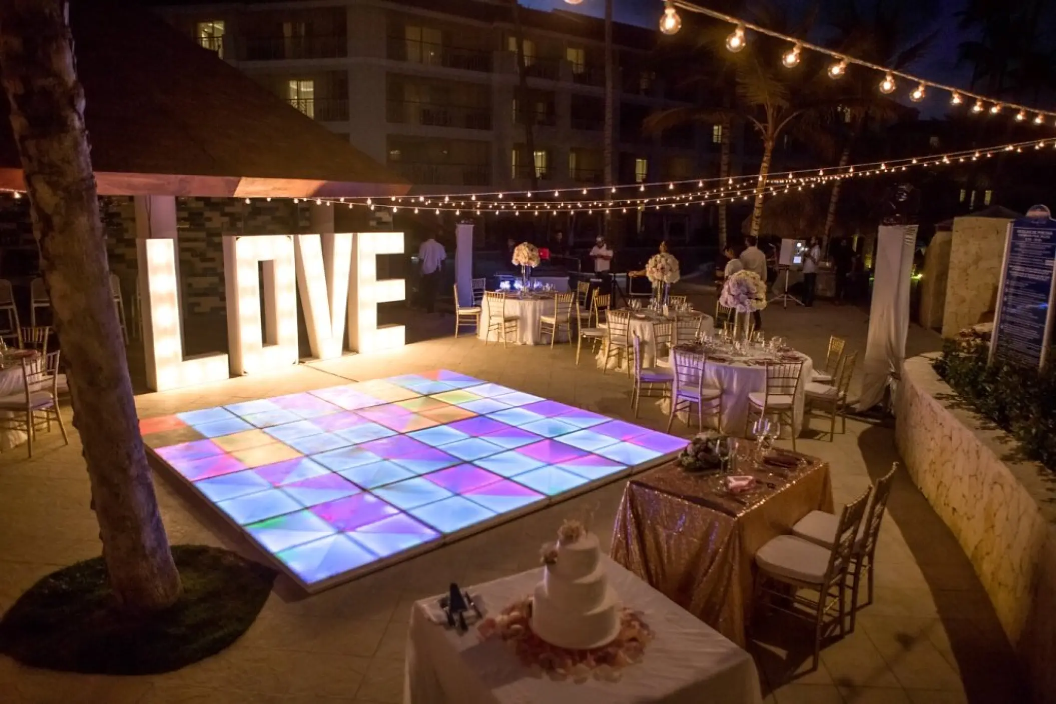 Evening wedding reception with an illuminated dance floor and LOVE sign at Majestic Mirage, Punta Cana