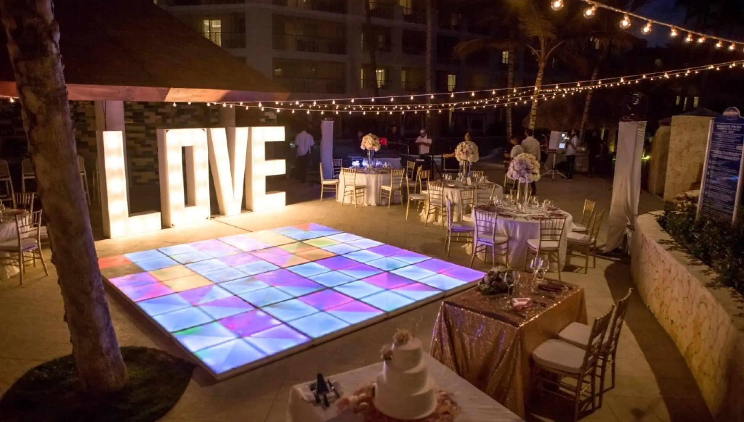 Evening wedding reception with an illuminated dance floor and LOVE sign at Majestic Mirage, Punta Cana