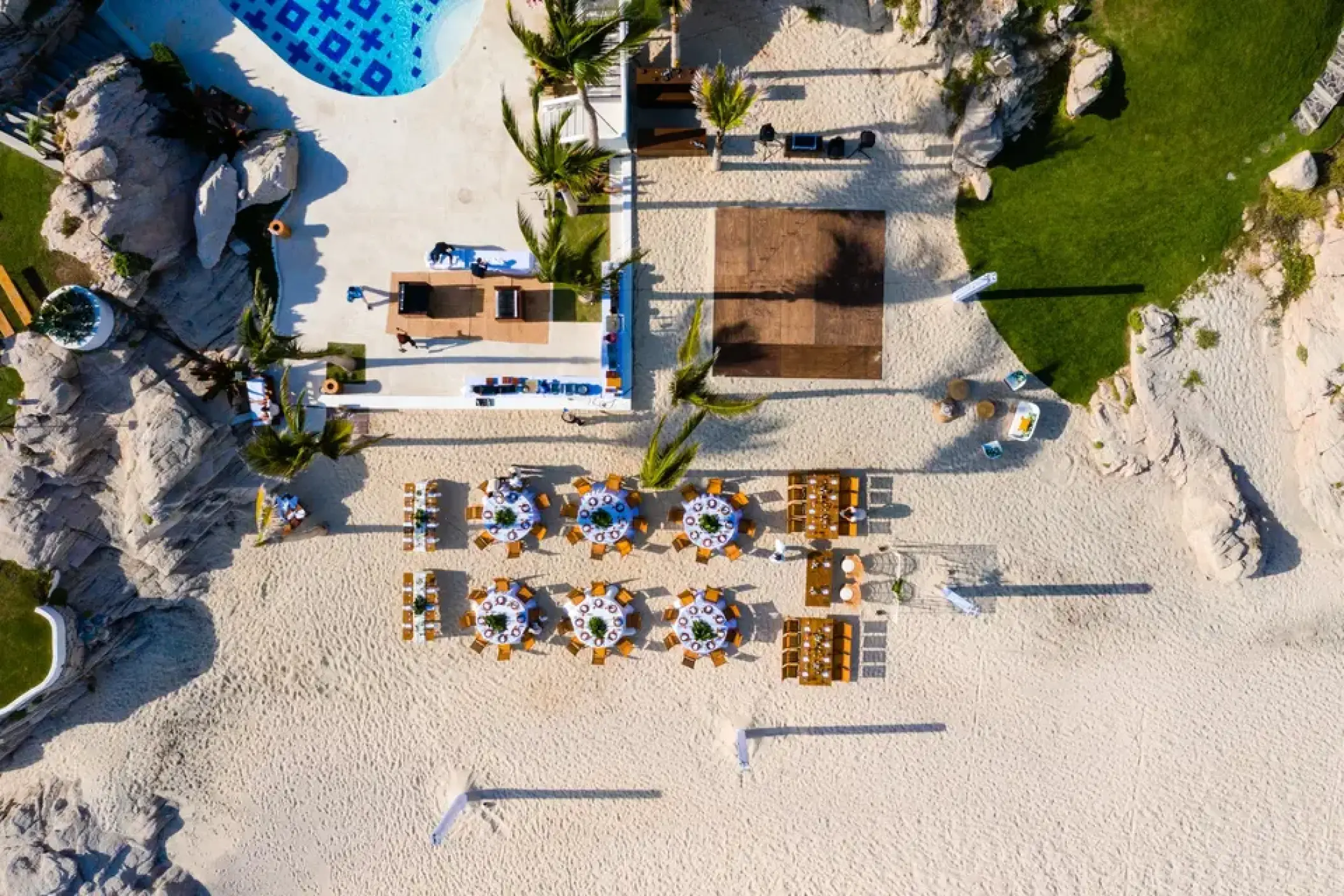 Aerial view of a beach wedding reception with round tables and a dance floor at Mar Del Cabo, Cabo San Lucas
