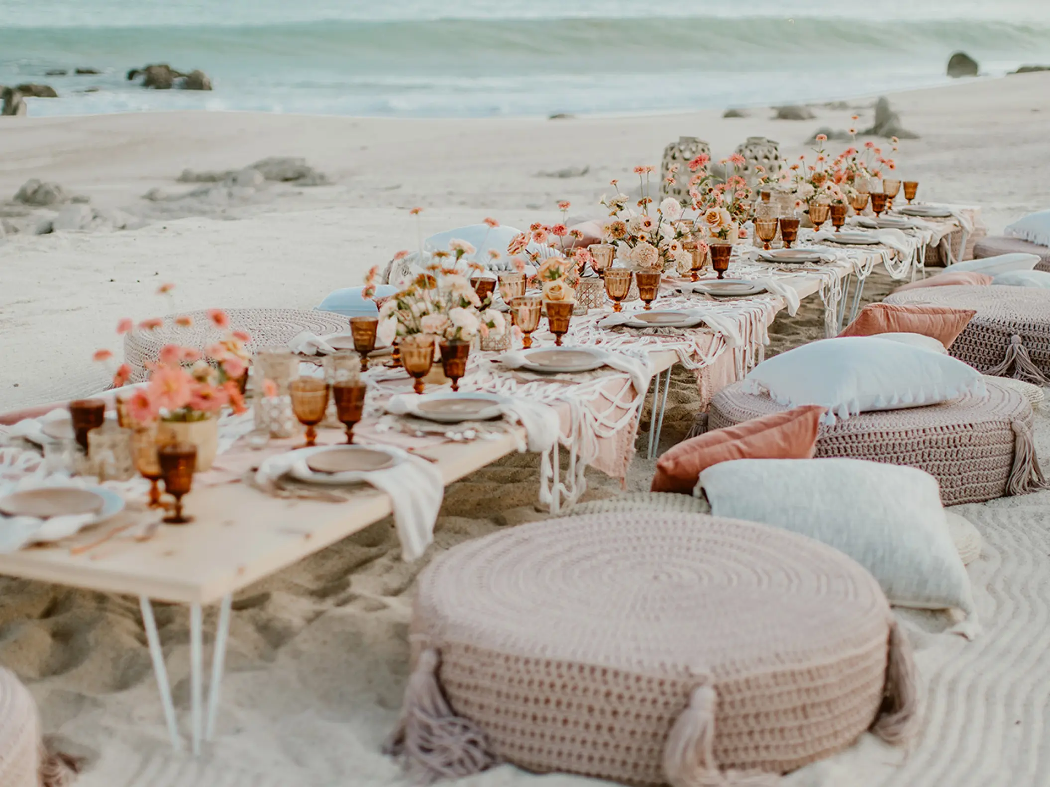 Boho beach reception setup with low tables and floor cushions at Mar Del Cabo, Cabo San Lucas
