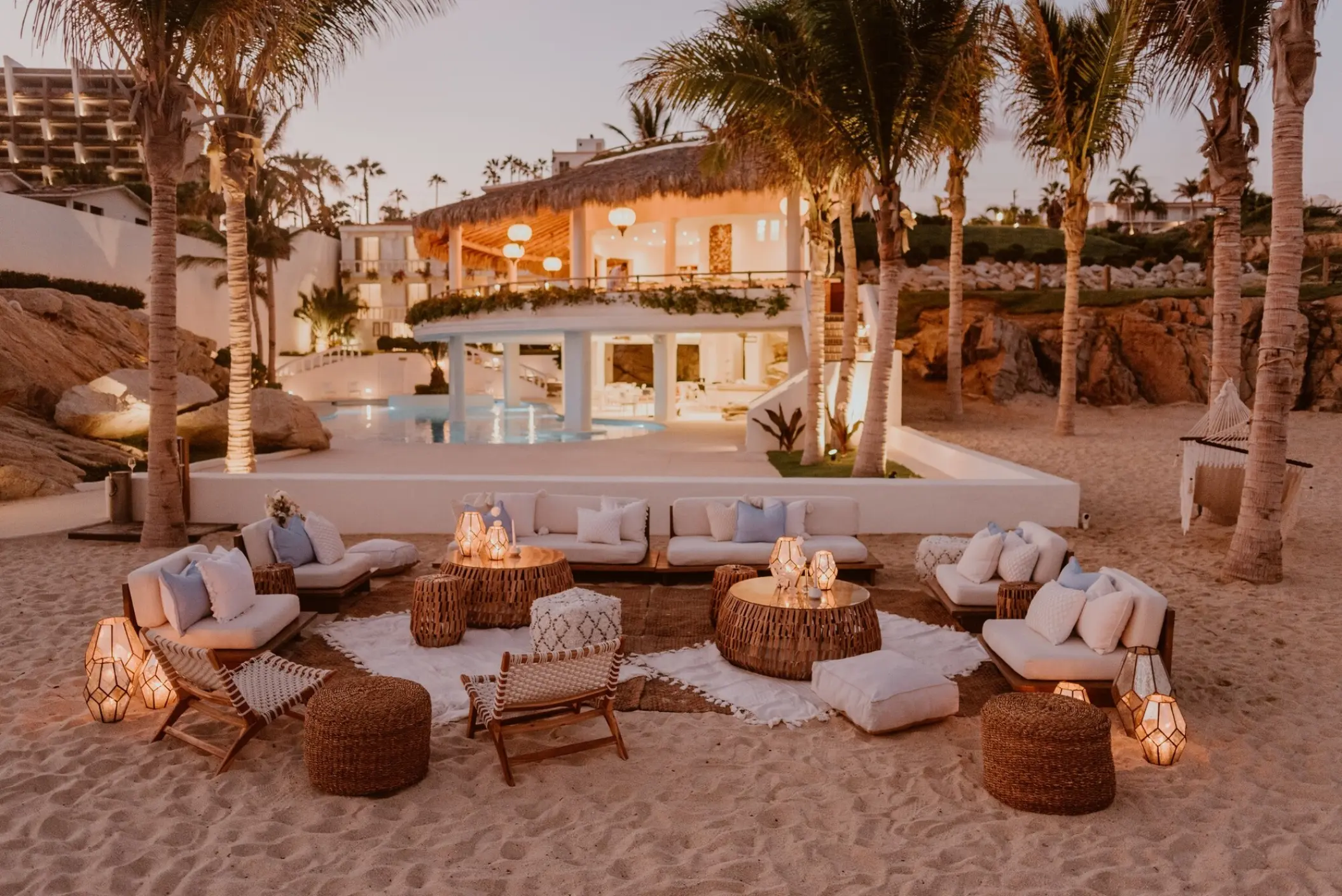Beach lounge with white sofas and wicker tables at Mar Del Cabo, Cabo San Lucas