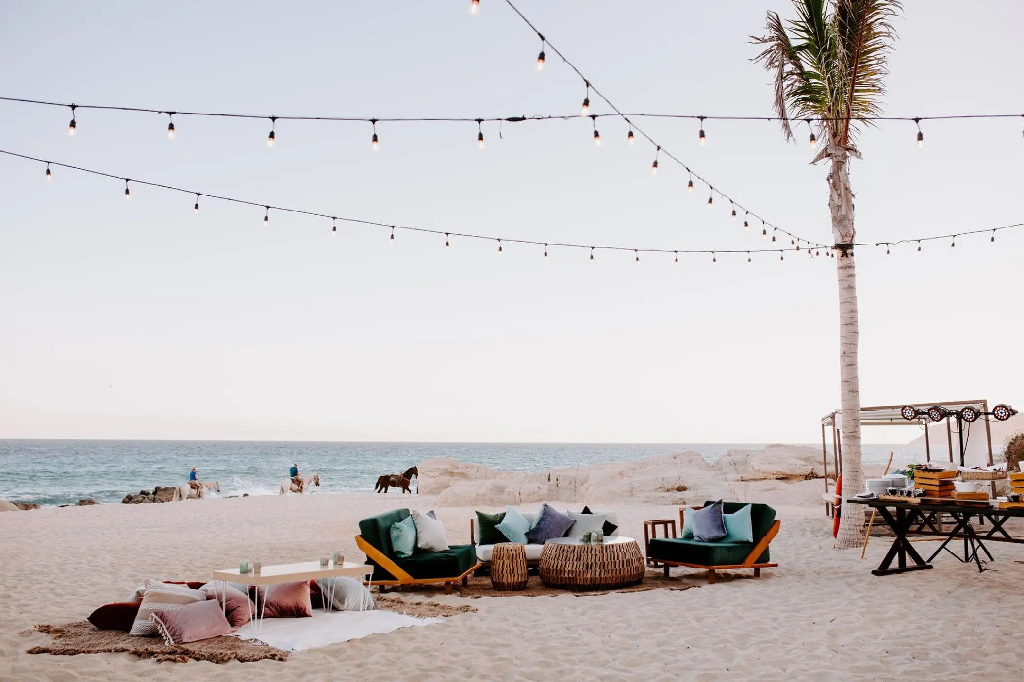 Outdoor lounge with sofas and string lights for a beach wedding reception at Mar Del Cabo, Cabo San Lucas