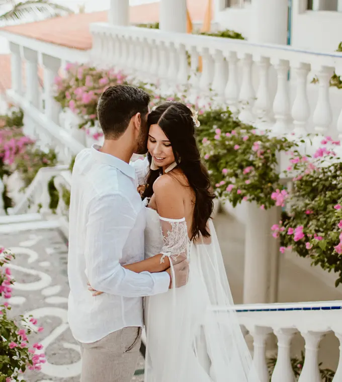 The couple embracing on a floral balcony at Mar Del Cabo, Cabo San Lucas