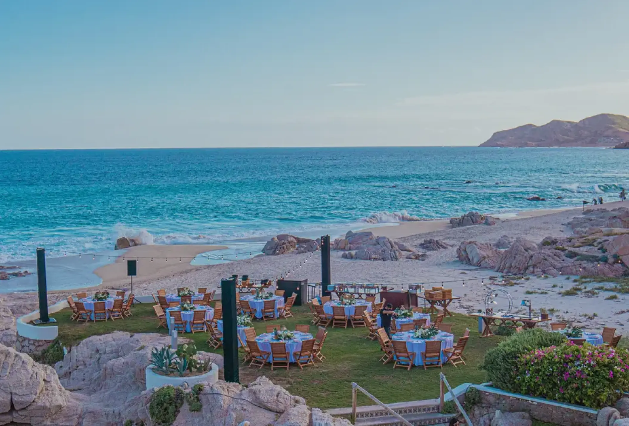 Outdoor wedding reception on a lawn overlooking the beach at Mar Del Cabo, Cabo San Lucas