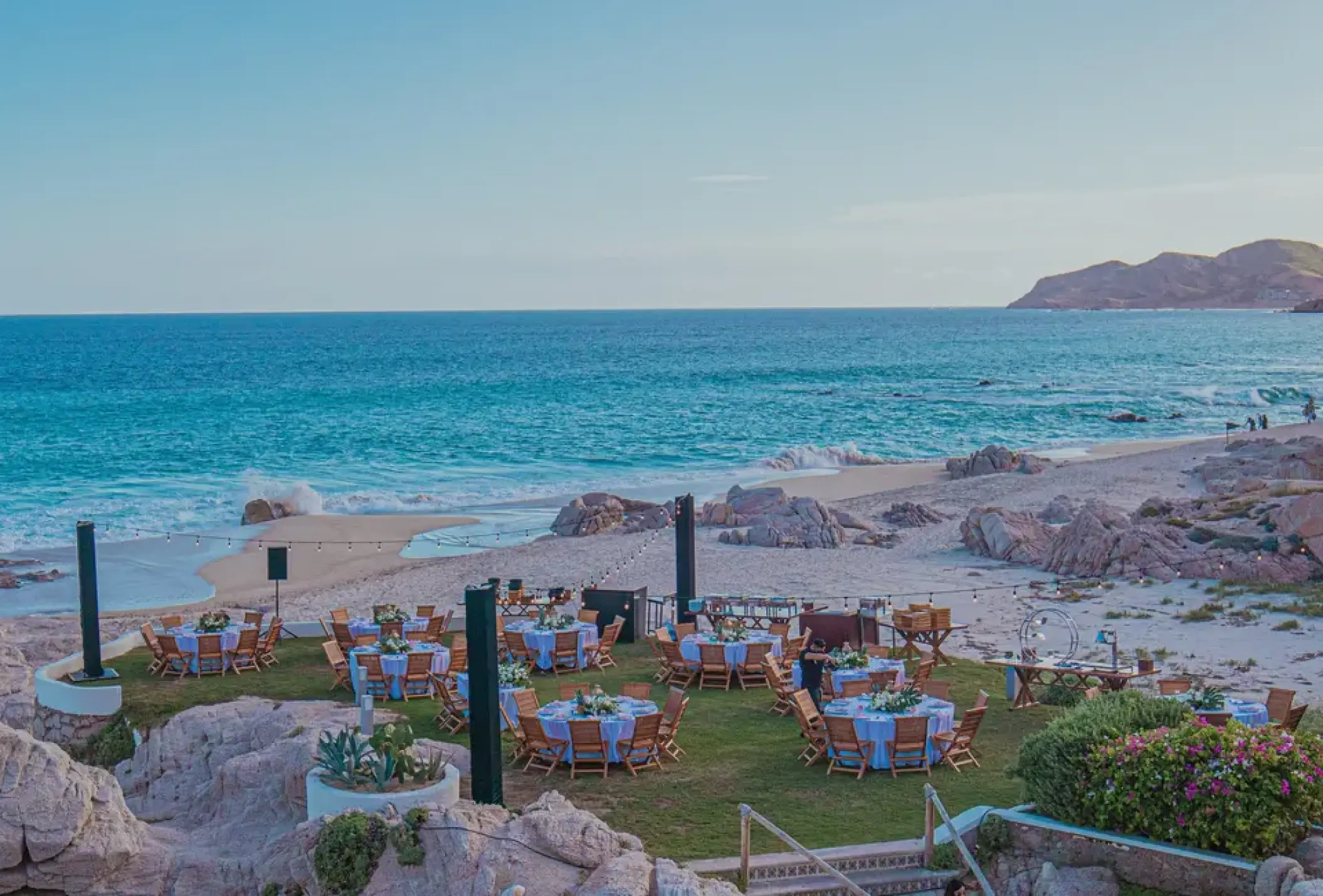 Outdoor wedding reception on a lawn overlooking the beach at Mar Del Cabo, Cabo San Lucas
