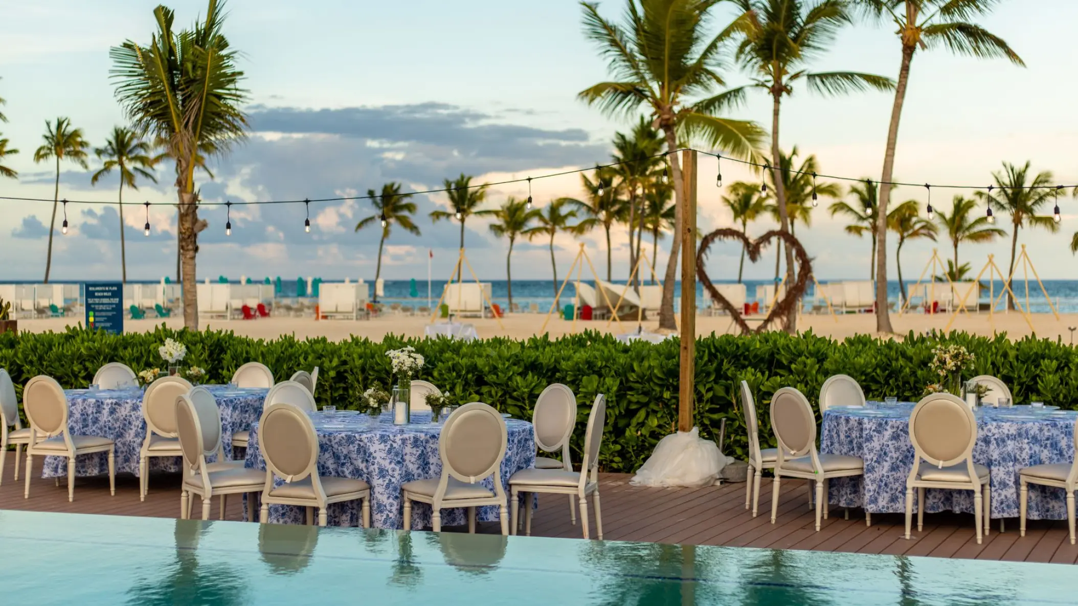 Poolside wedding reception tables and palm trees at Margaritaville Island Reserve Cap Cana, Punta Cana