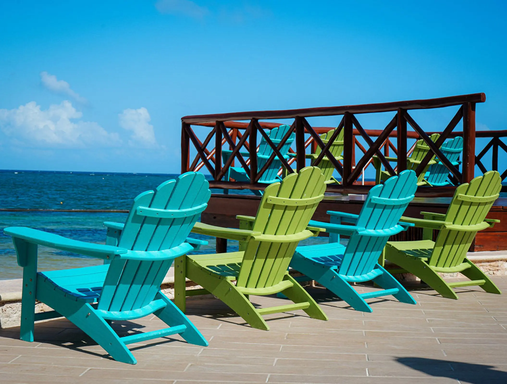 Colorful blue and green beach chairs on a terrace at Margaritaville Island Reserve Riviera Cancun