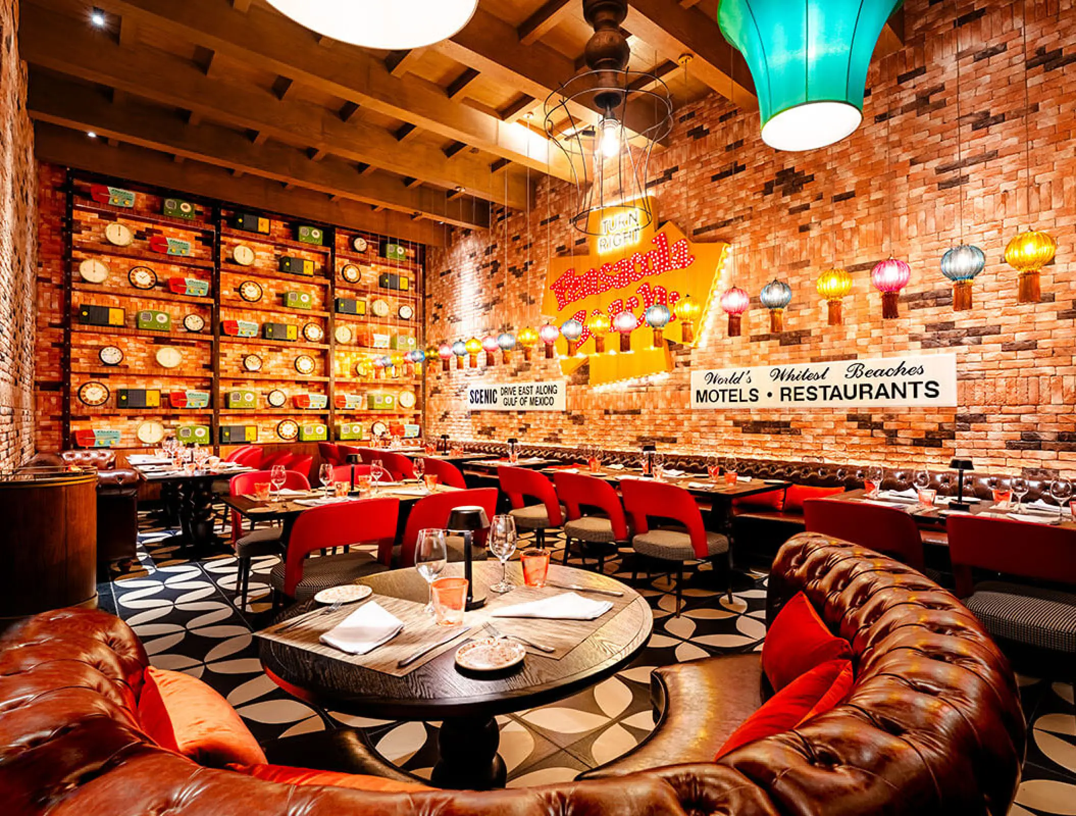 Frank & Lola's restaurant interior with brick walls and leather booths at Margaritaville Riviera Maya