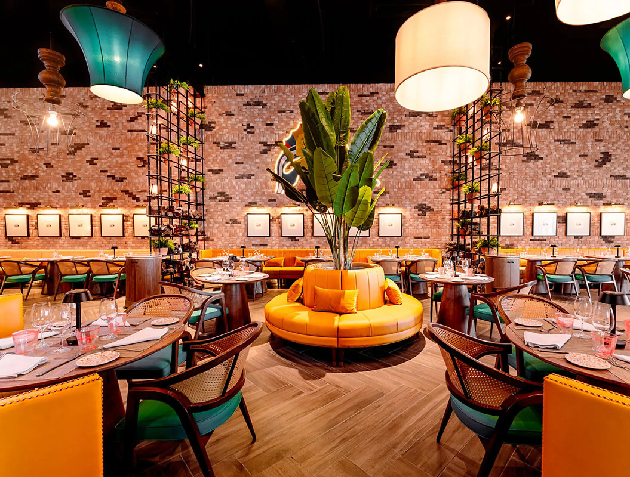Frank & Lola's restaurant interior with brick walls and circular seating at Margaritaville Riviera Maya
