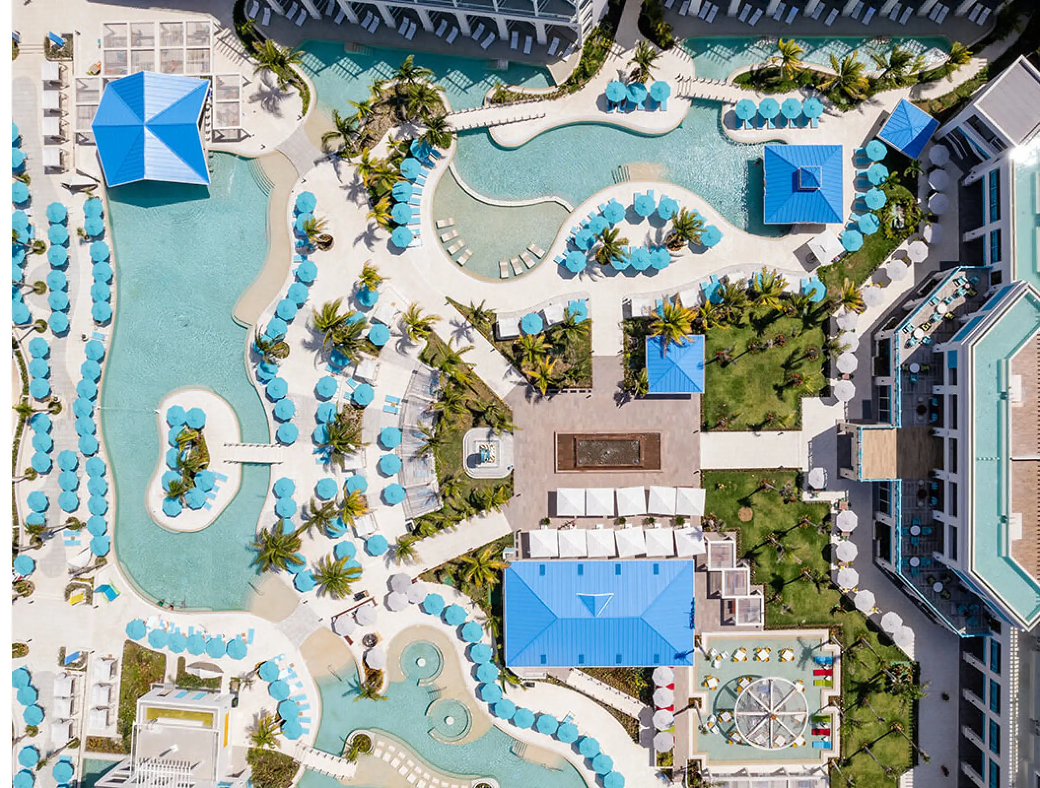 Aerial view of swimming pools and blue umbrellas at Margaritaville Island Reserve, Riviera Maya