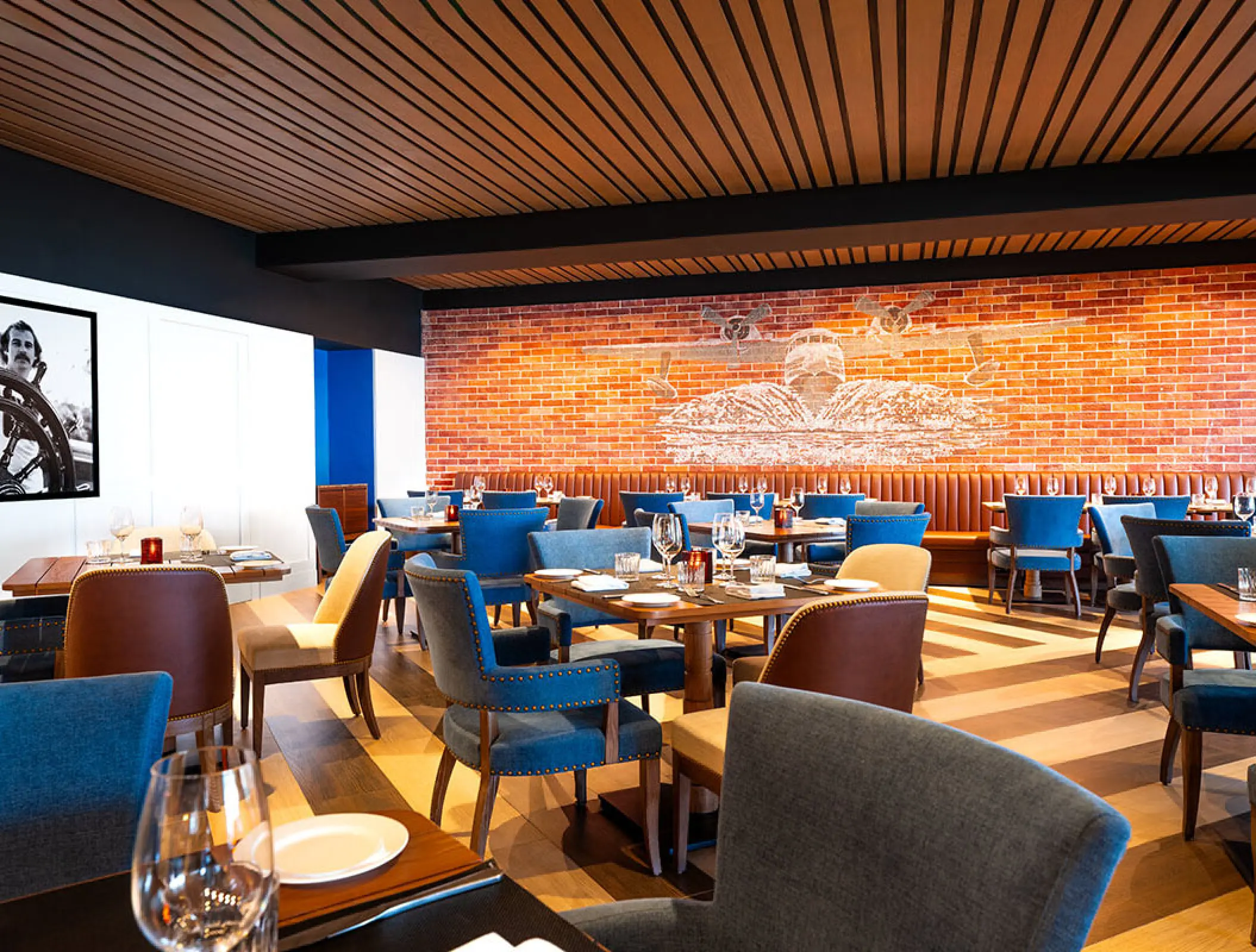 JWB Steakhouse dining room with blue chairs and brick wall at Margaritaville Island Reserve Riviera Maya