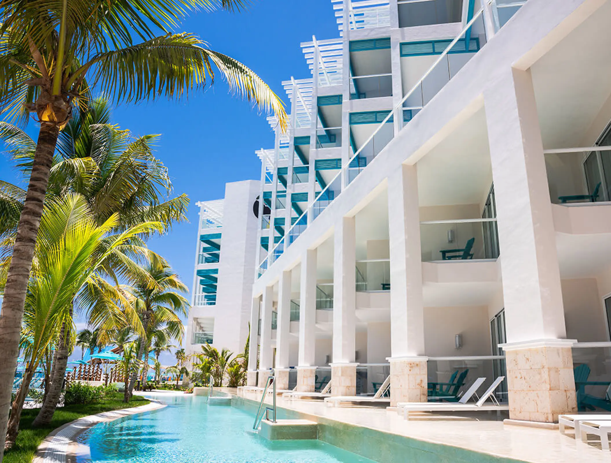 Swim-up suites and white architecture by the pool at Margaritaville Island Reserve Riviera Maya