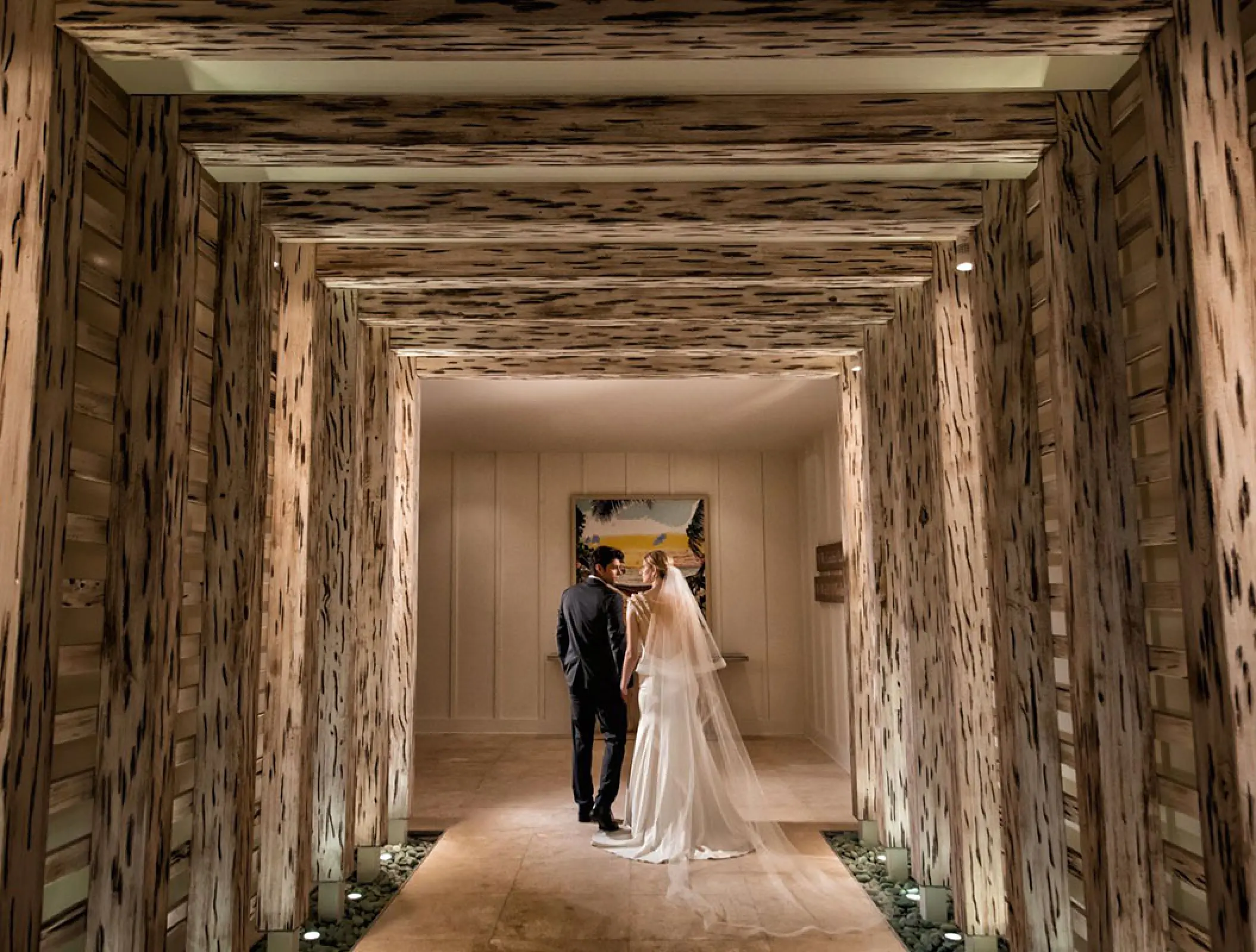 The bride and groom standing in a wooden tunnel at Margaritaville Island Reserve Riviera Maya