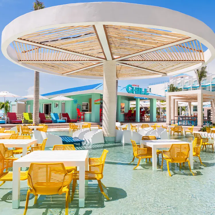 Margaritaville Riviera Maya License to Chill wet feet bar with yellow chairs in shallow pool water
