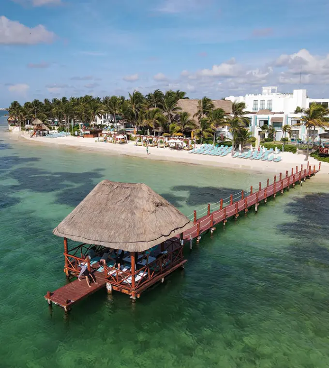Aerial view of the beachfront and overwater pier palapa at Margaritaville Riviera Cancun