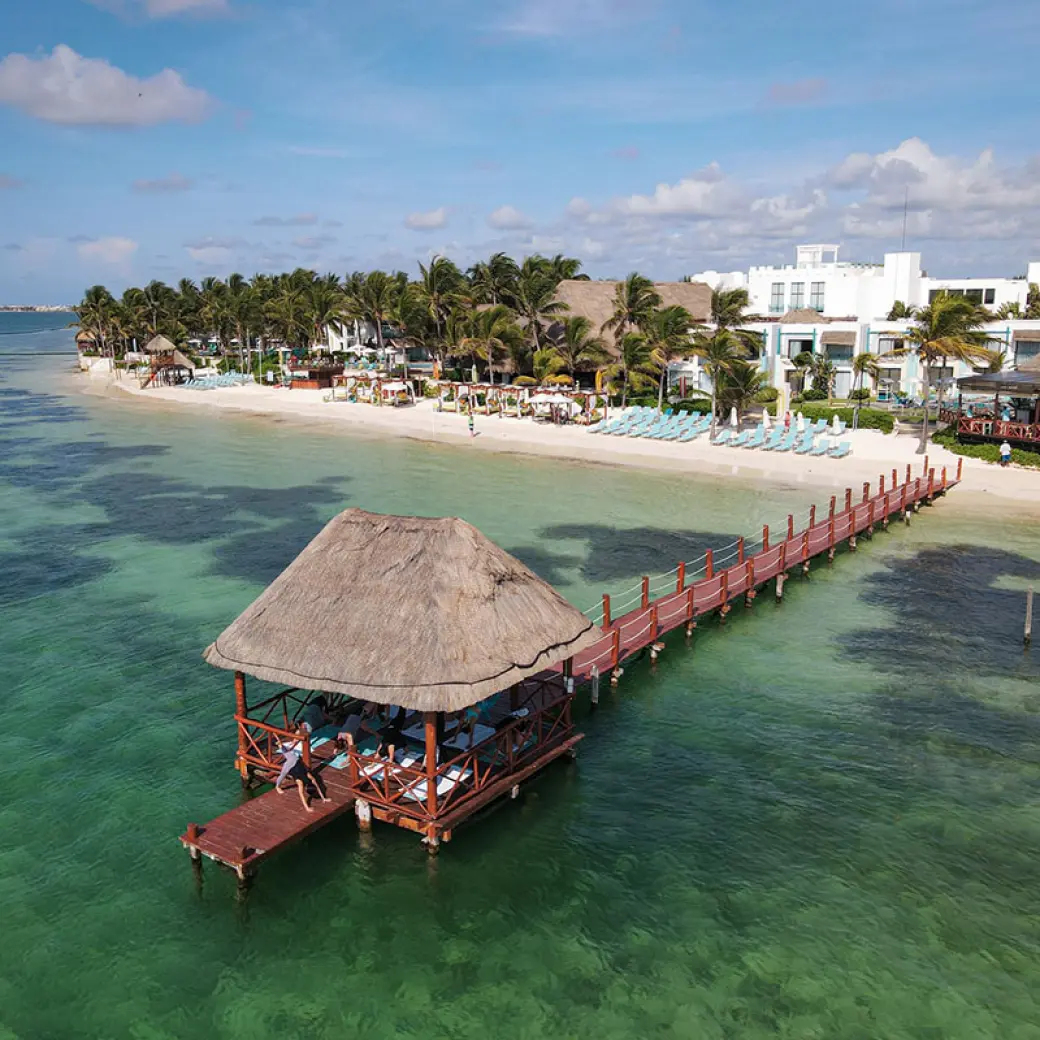 Aerial view of the beachfront and overwater pier palapa at Margaritaville Riviera Cancun