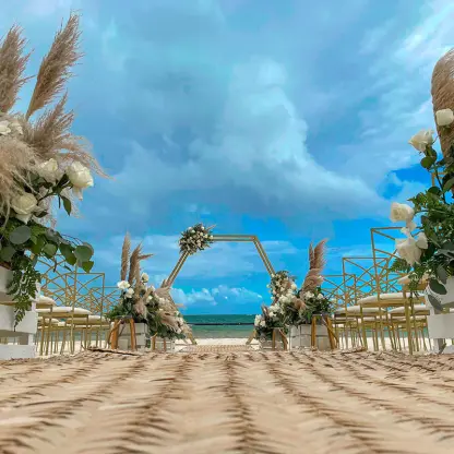 Beachfront wedding ceremony with pampas grass and white flowers at Margaritaville Island Reserve, Cancun
