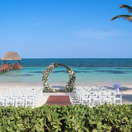 Beachfront wedding ceremony with circular floral arch at Margaritaville Island Reserve Riviera Cancun, Cancun