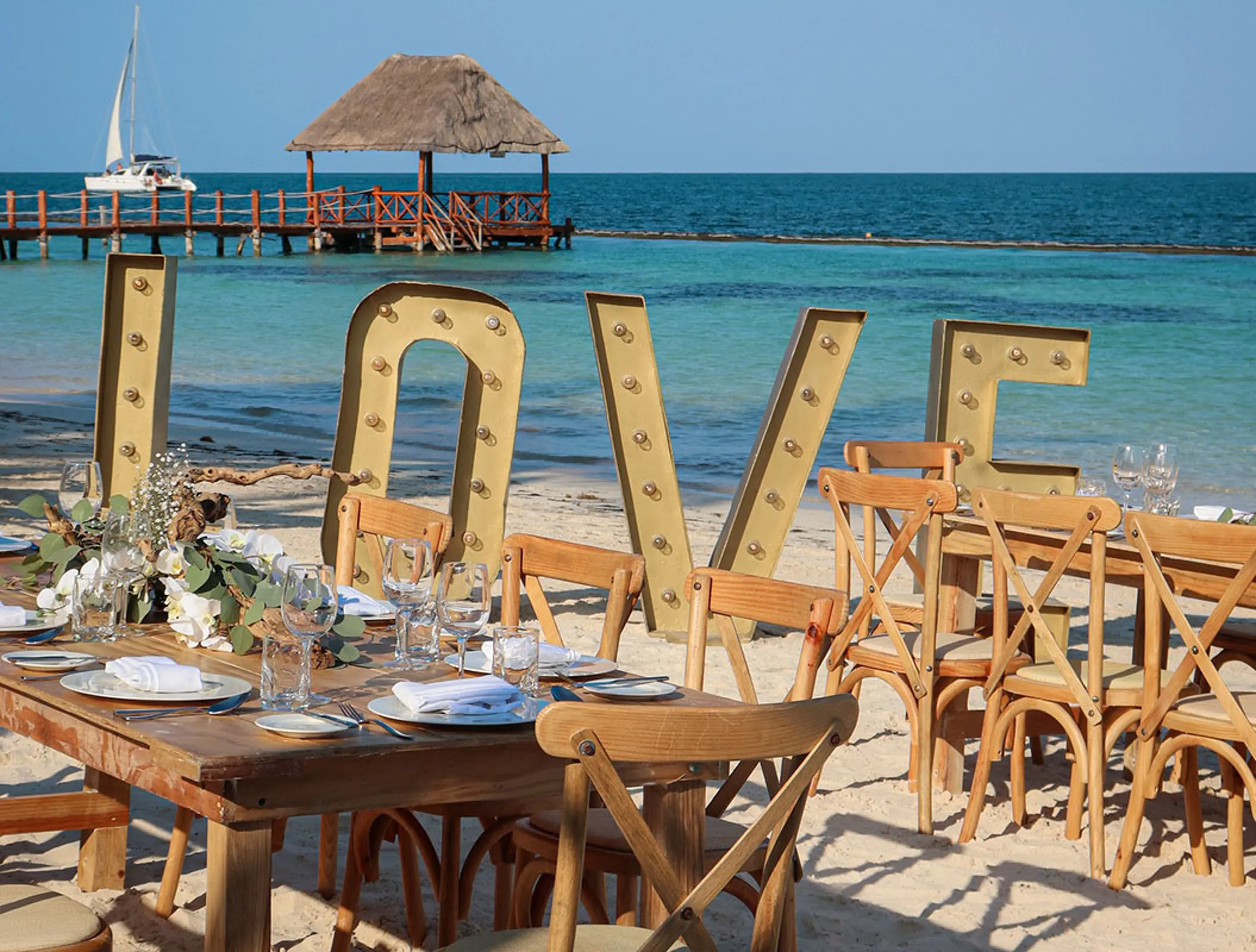 Marquee LOVE sign behind a beach wedding reception at Margaritaville Island Reserve Riviera Cancun