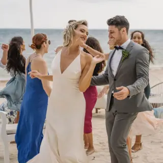 Bride and groom dancing with guests at a beach wedding cocktail hour at Margaritaville Island Reserve Riviera Cancun