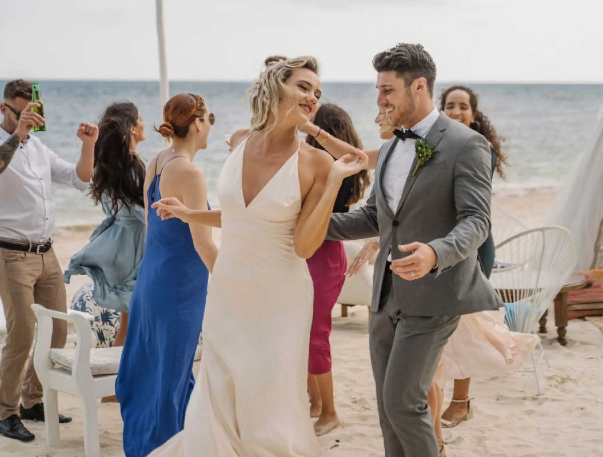 Couple dancing with guests at a beachfront wedding cocktail hour at Margaritaville Island Reserve Riviera Cancun