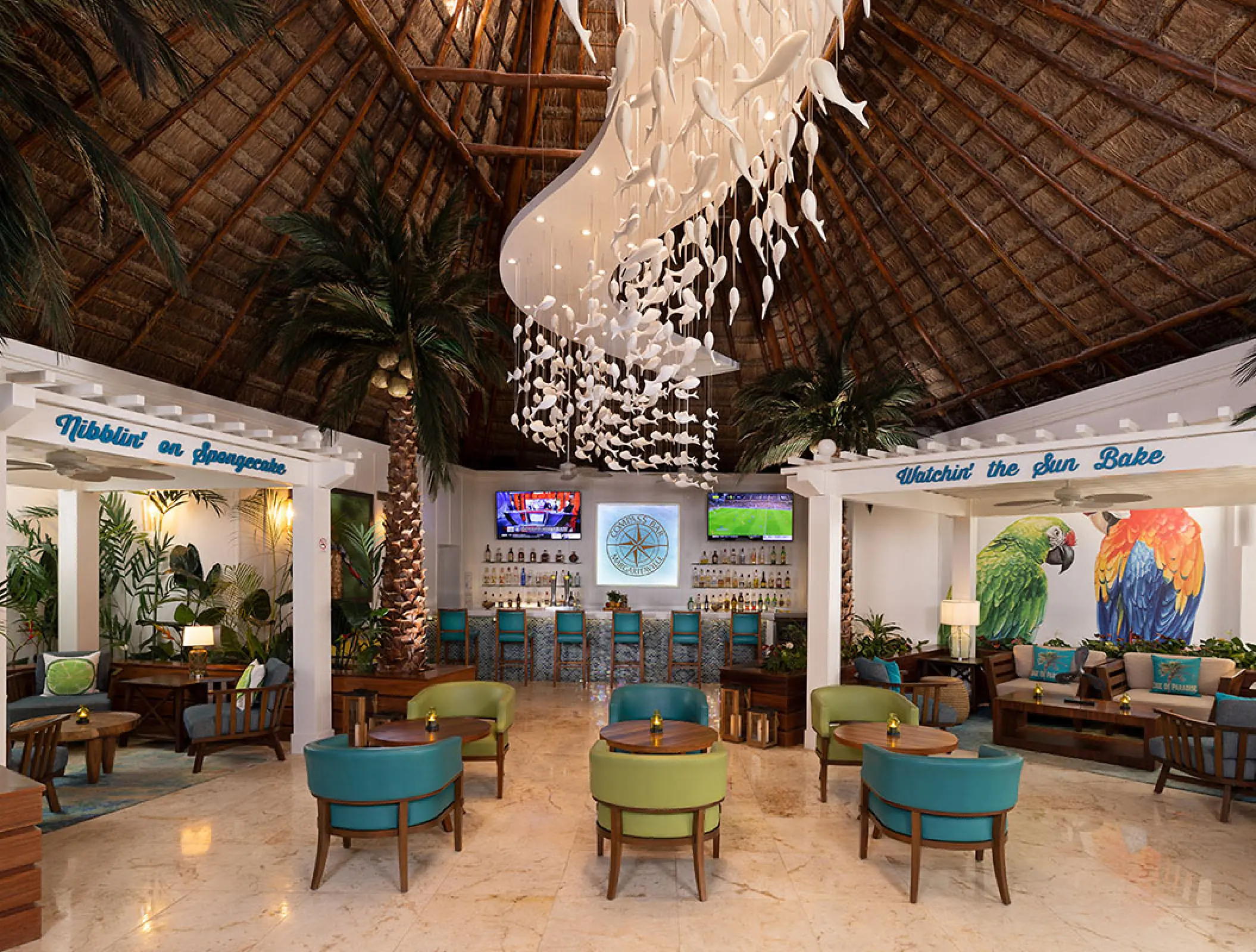 Lobby bar with a thatched roof and fish-inspired chandelier at Margaritaville Island Reserve Riviera Cancun, Cancun
