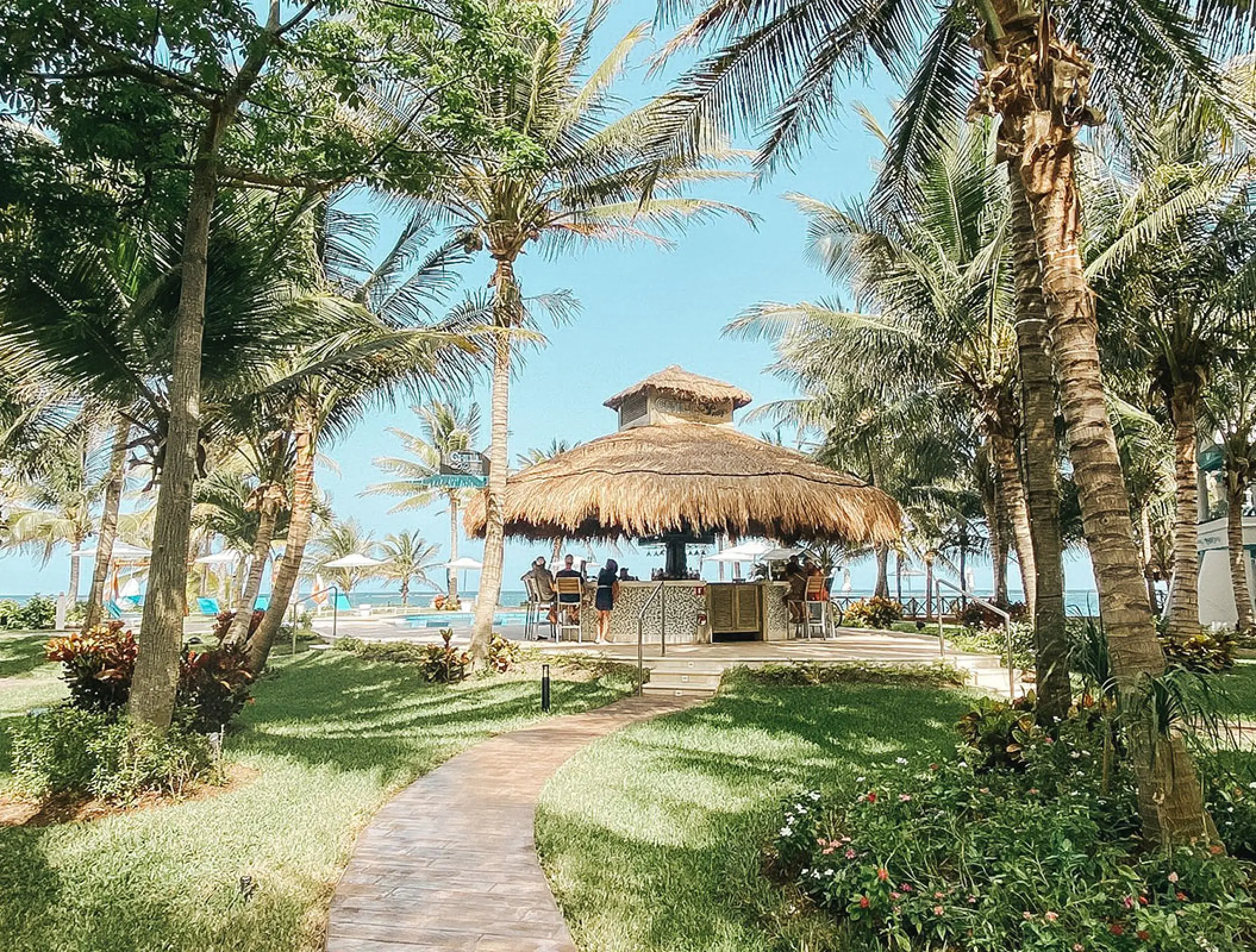 Thatched-roof pool bar surrounded by palm trees at Margaritaville Island Reserve Riviera Cancun, Cancun