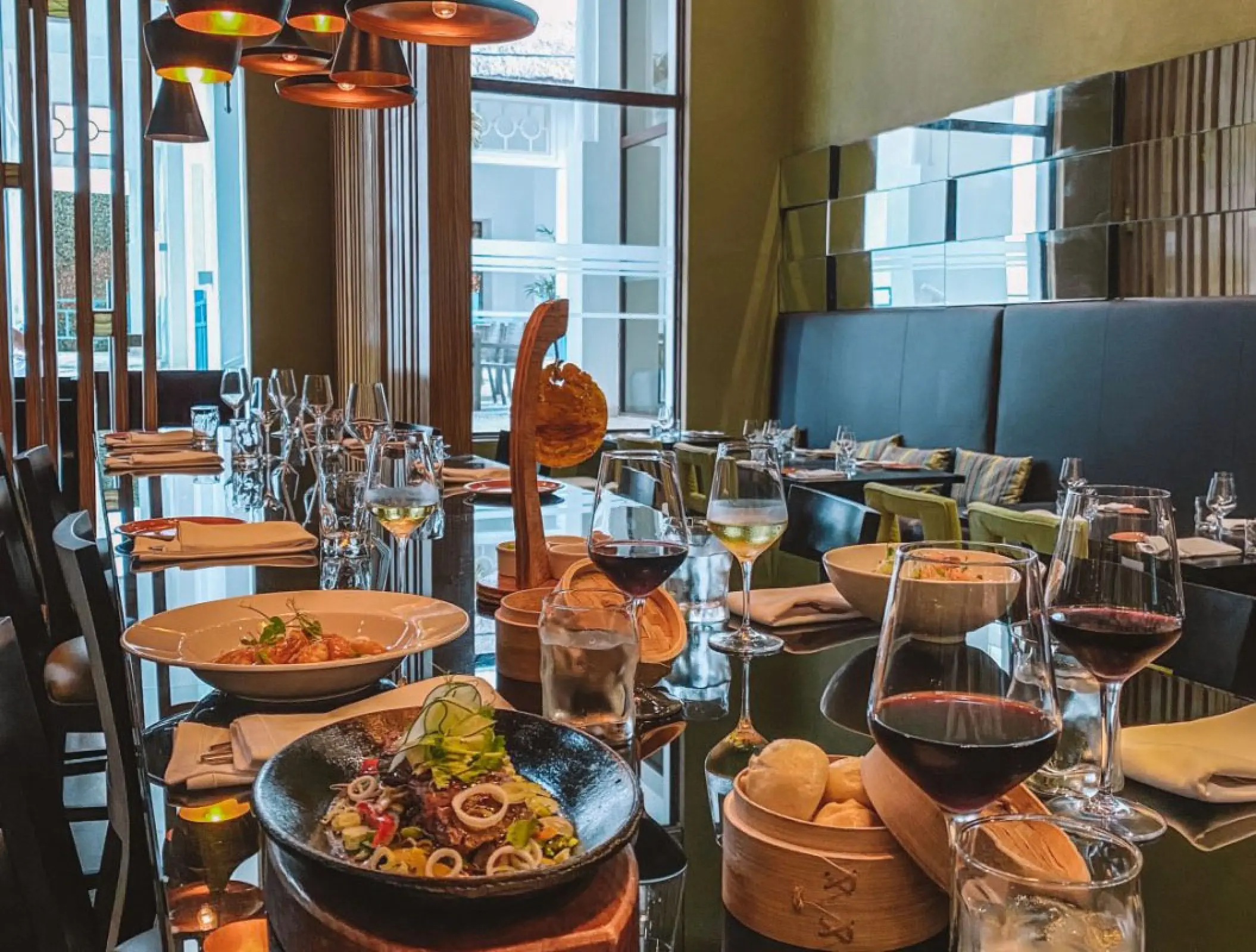 Steakhouse dining table set with red wine and plated appetizers at Margaritaville Island Reserve Riviera Cancun, Cancun