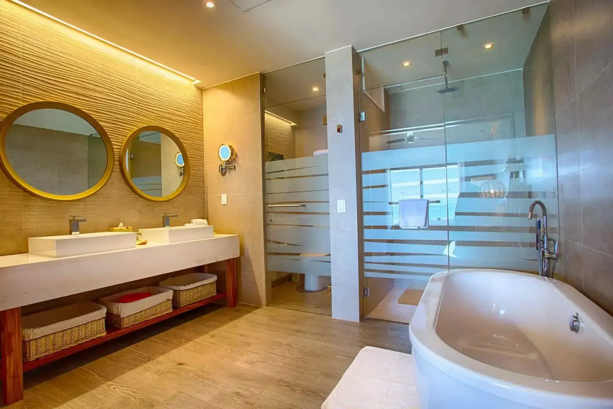 Modern bathroom with double vanity and freestanding soaking tub at Marival Armony, Puerto Vallarta