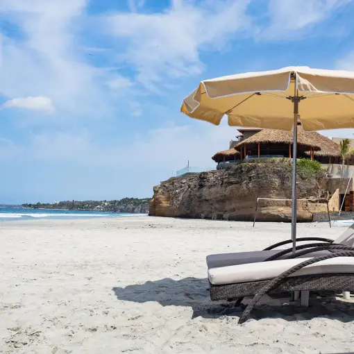 Lounge chairs and sun umbrella on the beach at Armony Marival, Puerto Vallarta